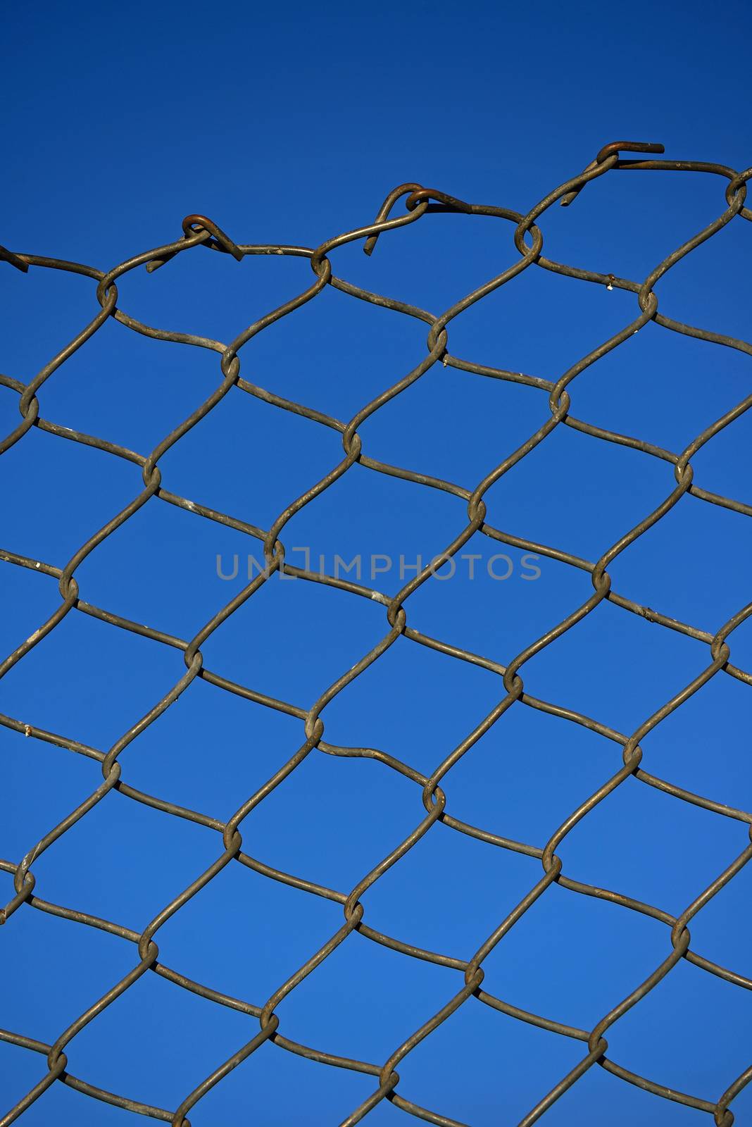 Steel net fence with blue sky background. by think4photop