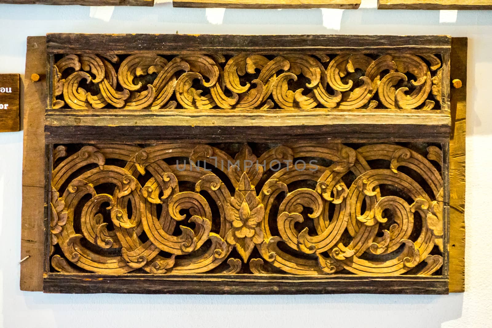 detail of wood carving with thai pattern on natural wood plate for decorated temple,Thailand