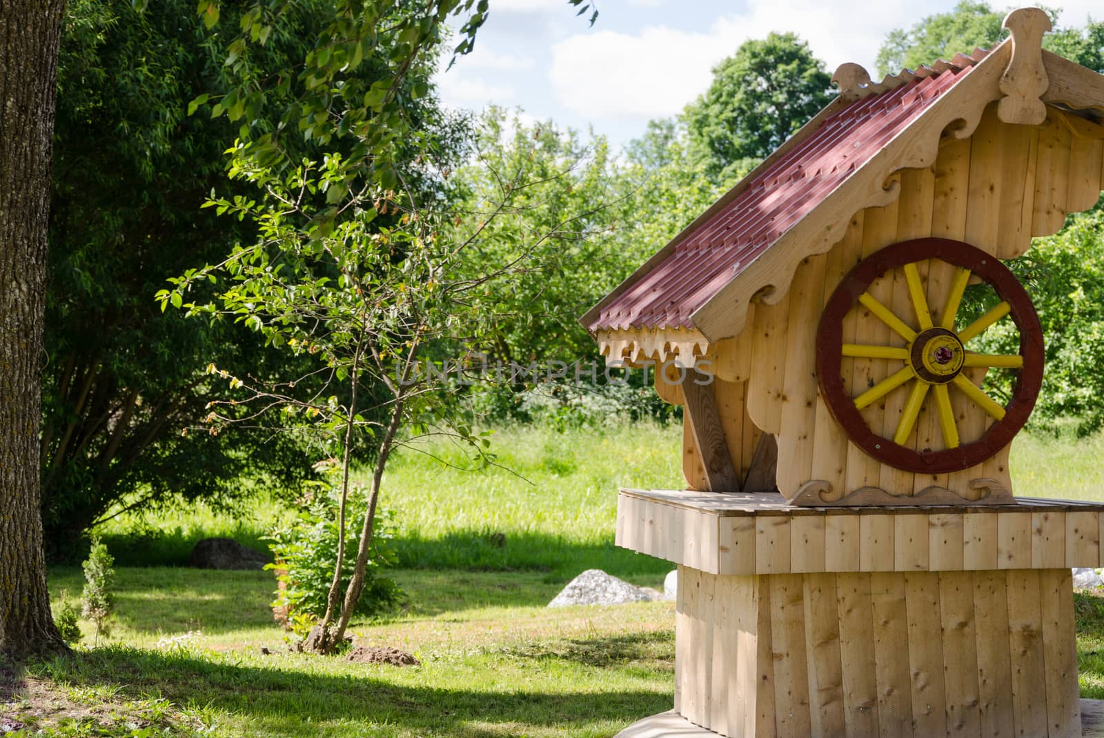 wooden handmade original well in summer garden