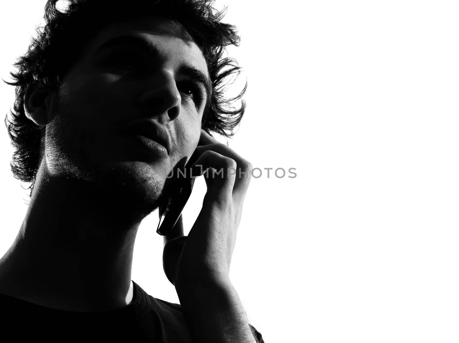 young man looking up telephone smiling portrait silhouette in studio isolated on white background