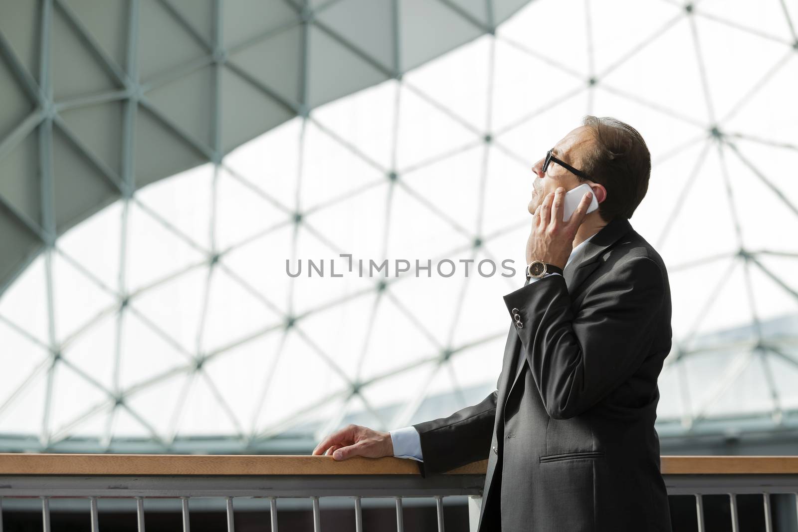 businessman in formal wear talking on phone by alessandroguerriero