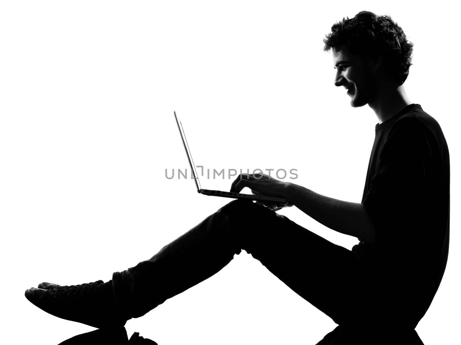 young man silhouette silhouette sitting computing computer laptop in studio isolated on white background