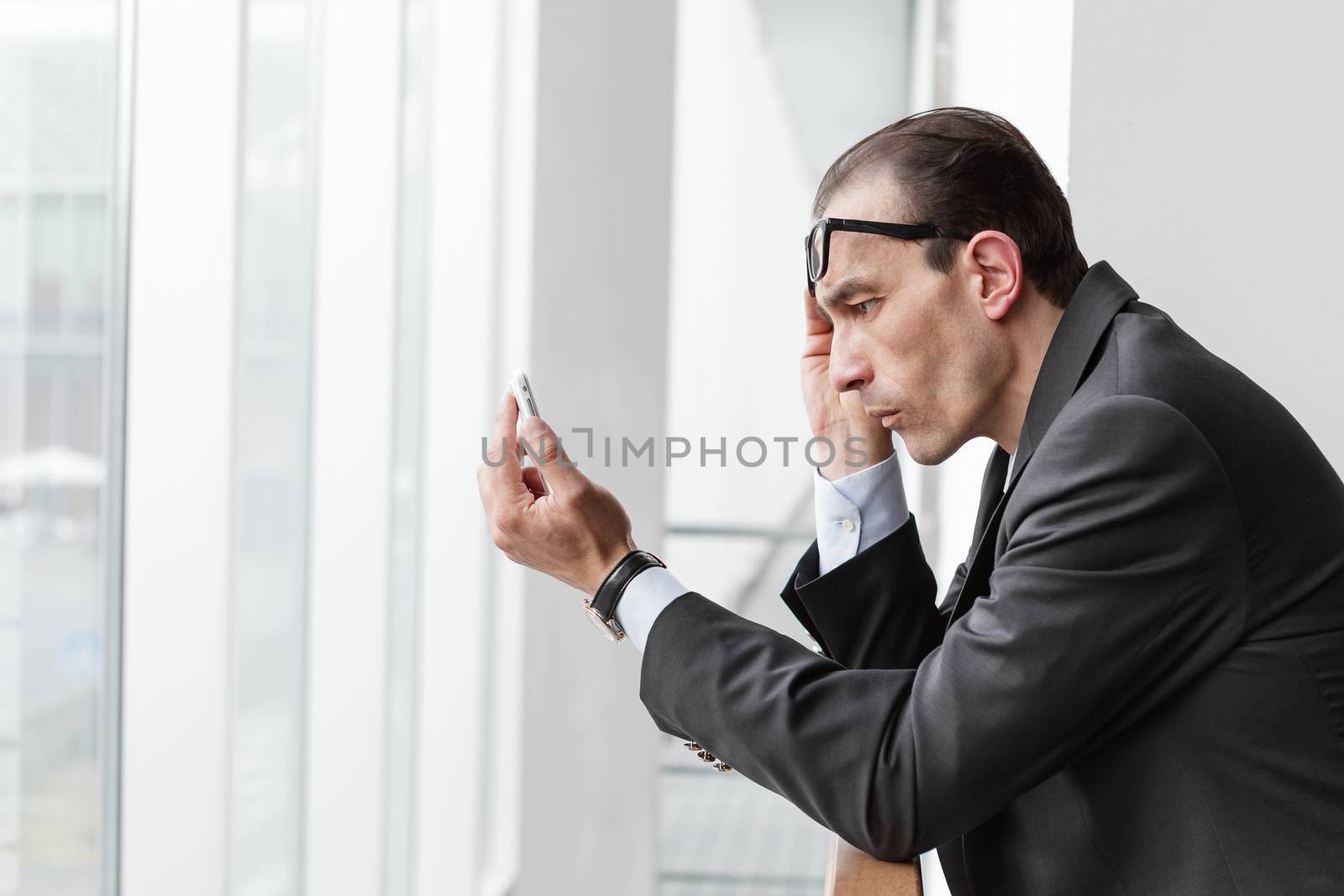 Poor eyesight Businessman trying to watch his phone display