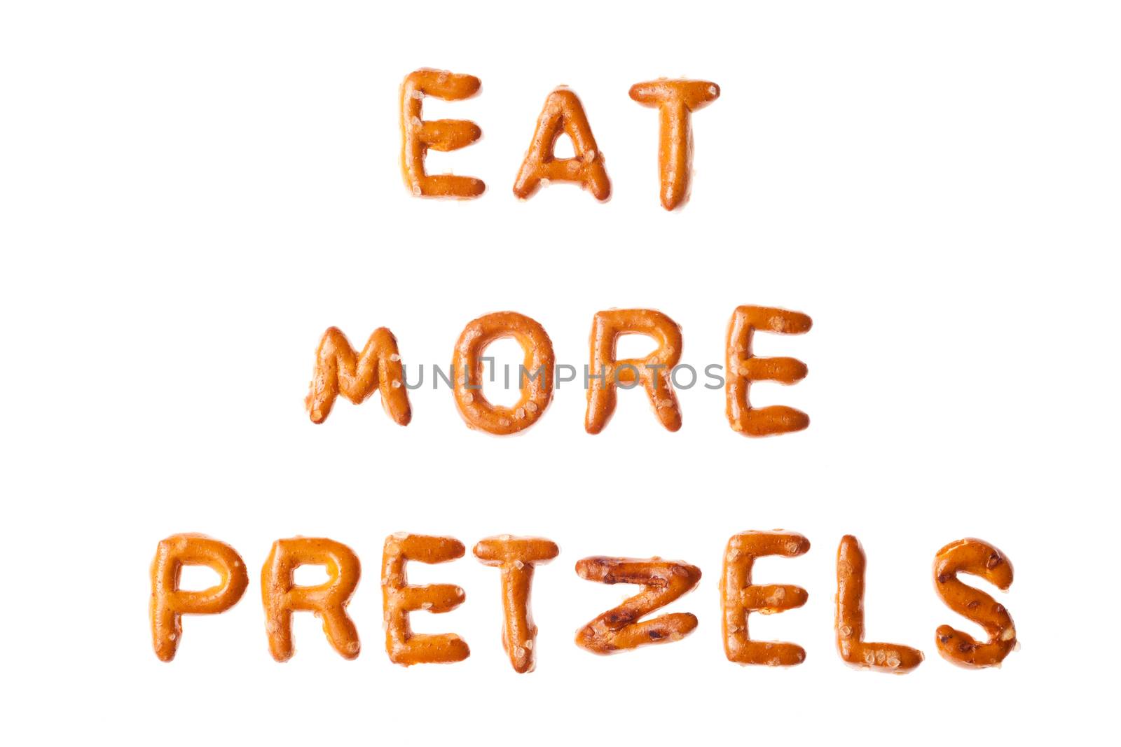 Words EAT MORE PRETZELS written, laid-out, with crispy alphabet letter pretzels isolated on white background