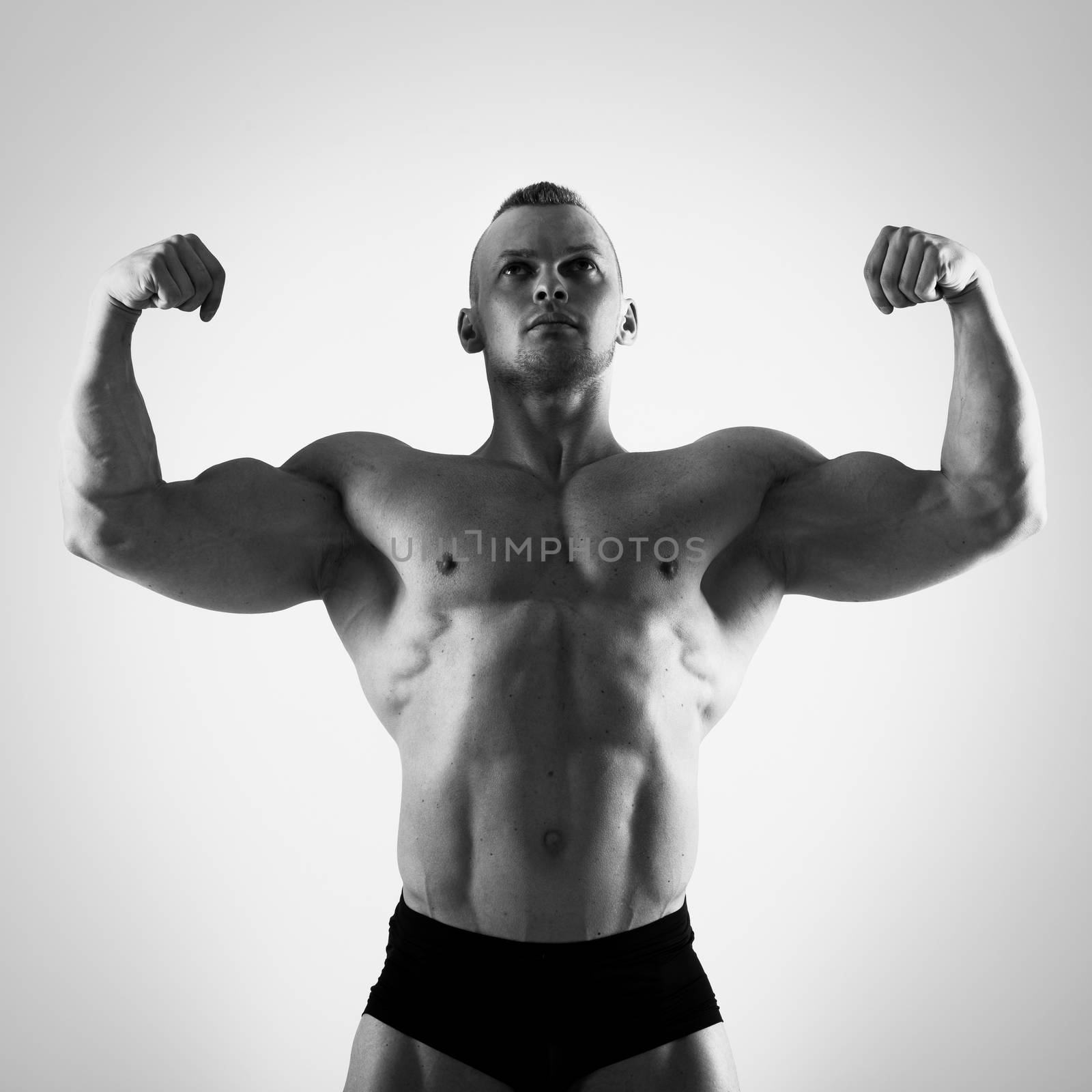 Fitness, bodybuilding. Powerful man on a white background