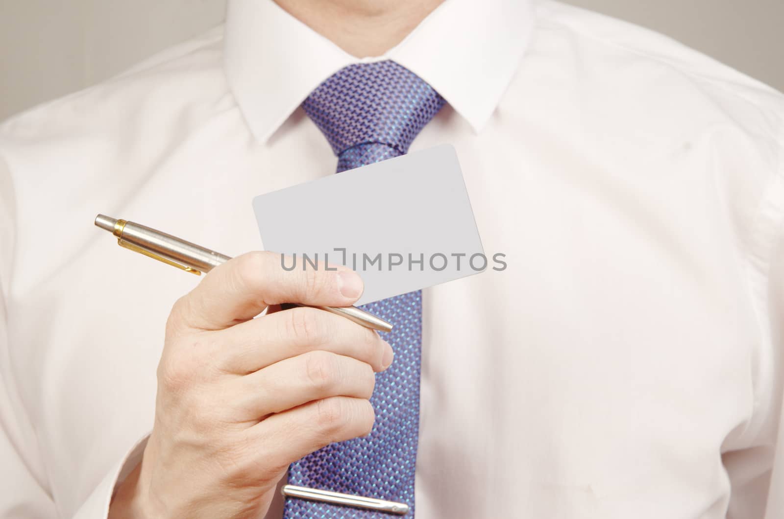 Businessman in white shirt holding pen and credit card