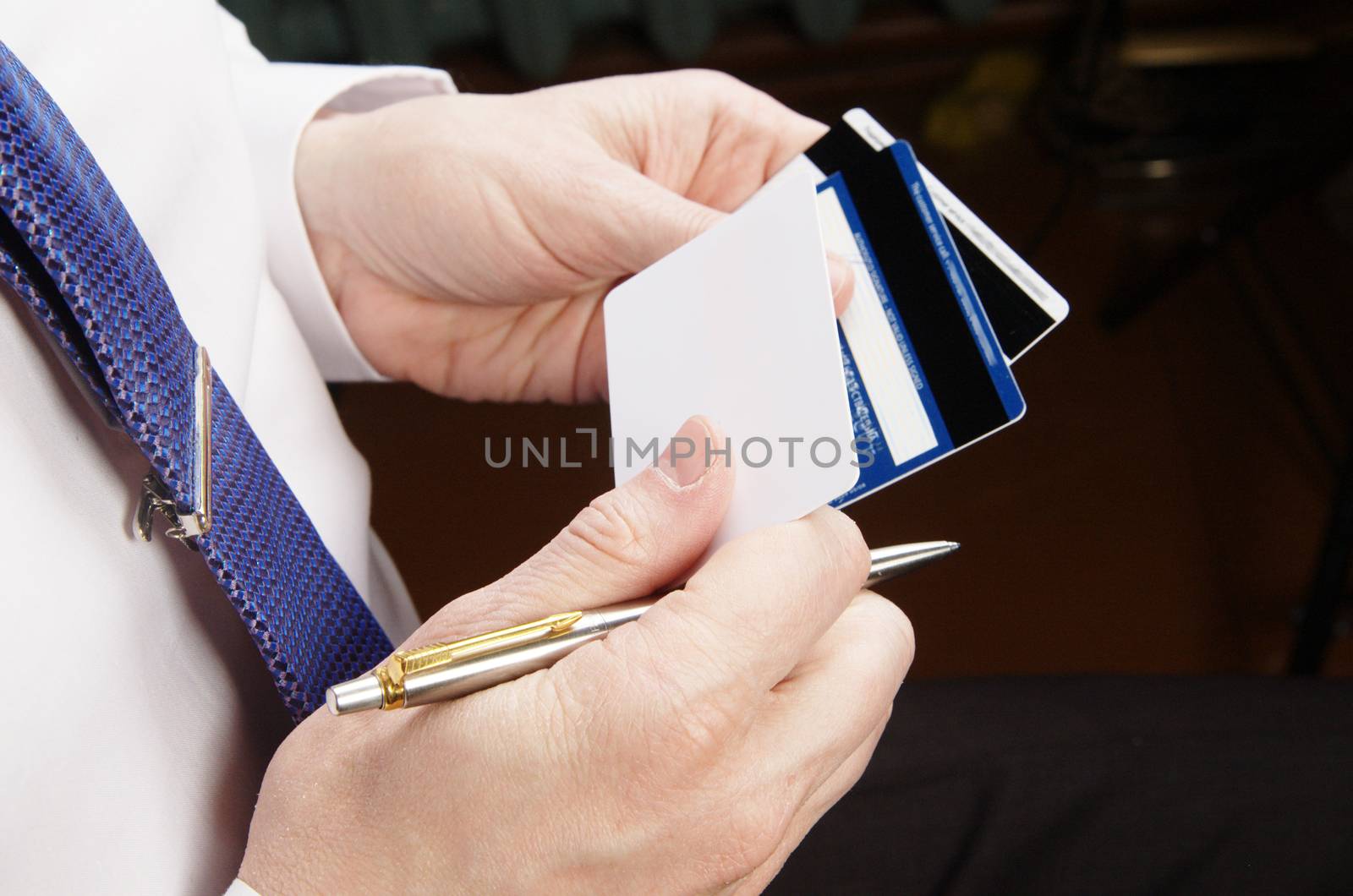 Businessman in white shirt holding credit cards and pen