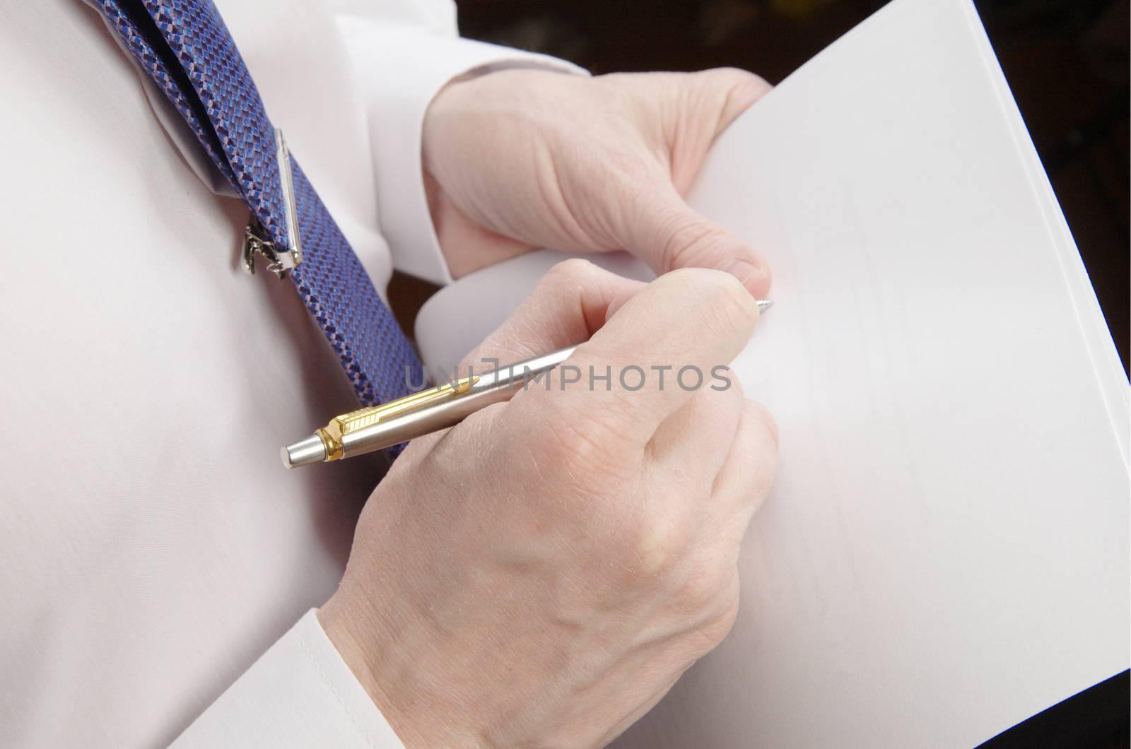 Businessman holding sheet of paper and pen by Ravenestling