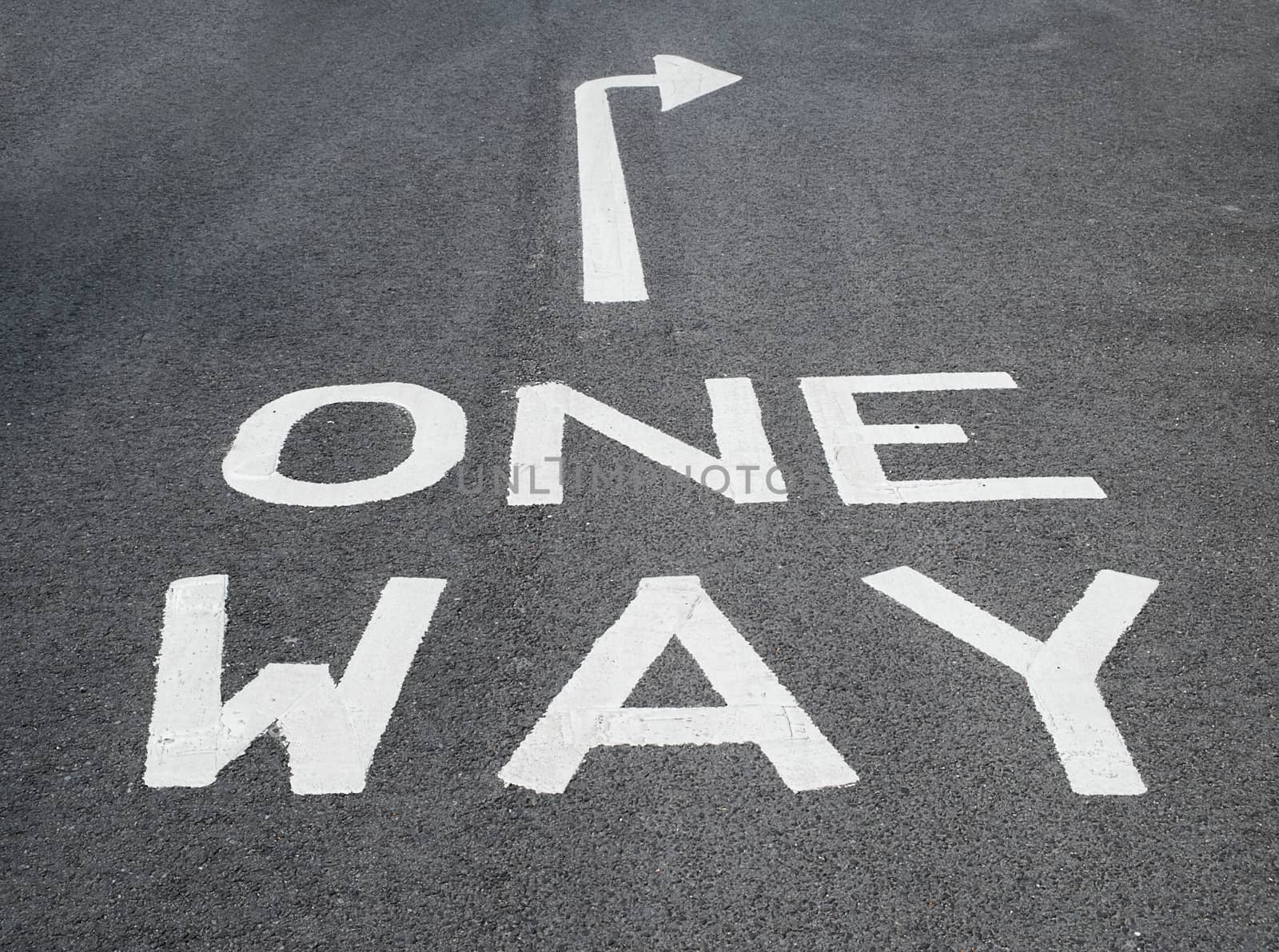 one way sign on tarmac road with arrow pointing right