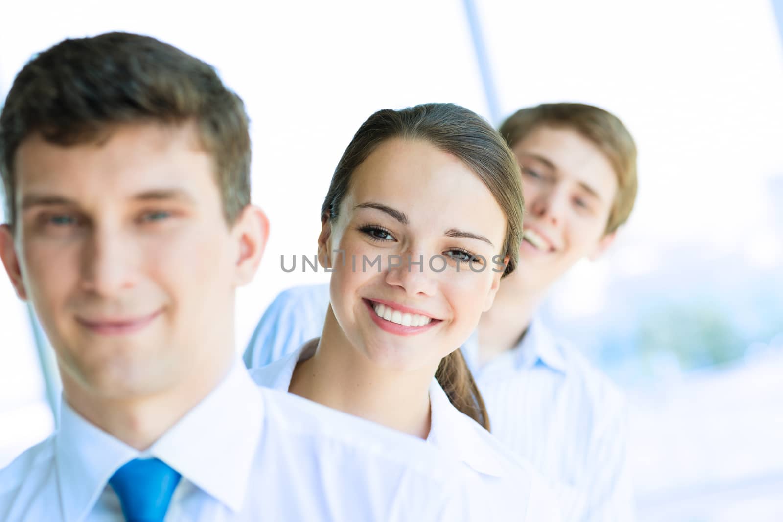 portrait of a young business woman standing in line with colleagues, concept of teamwork