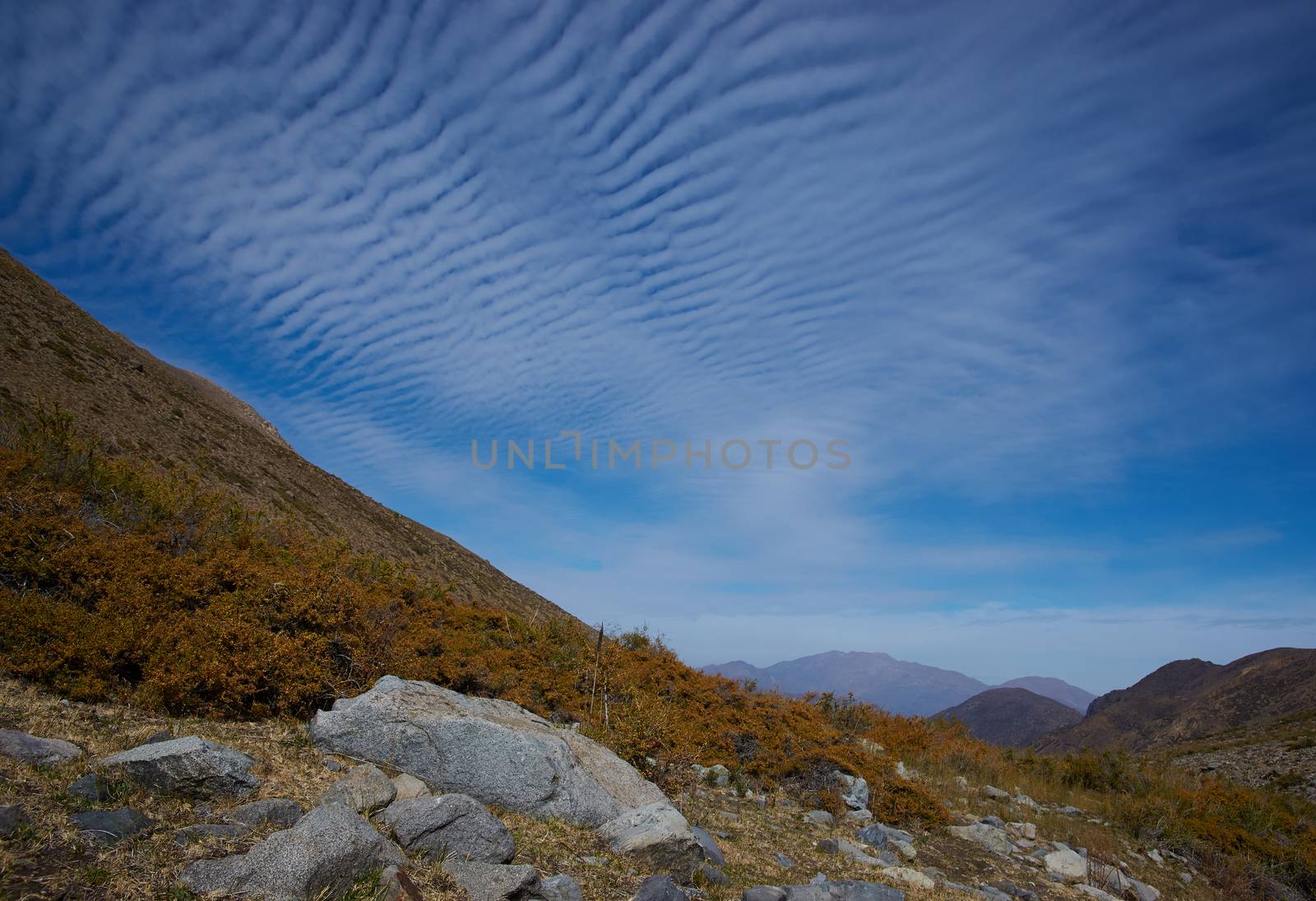 Intricate cloud formation above autumn coloured vegetation in the Yerba Loca Mountain Park near Santiago in Chile
