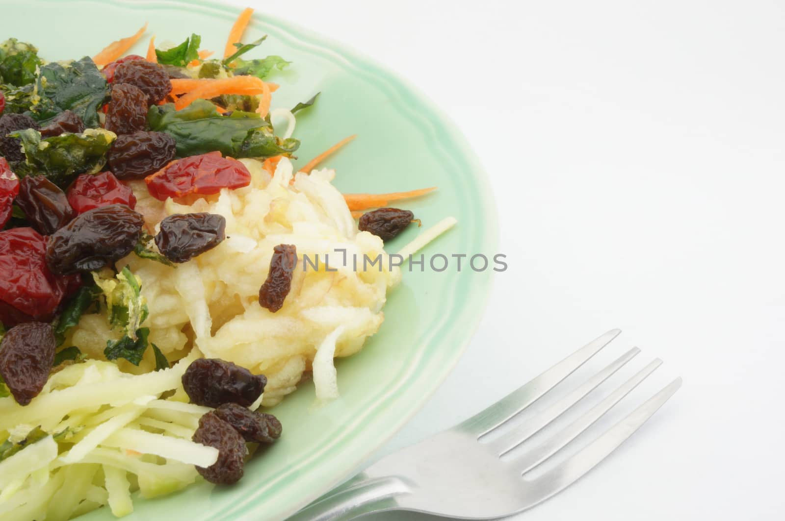 Healthy Salad consists apple carrots mango raisins and tomatoes.