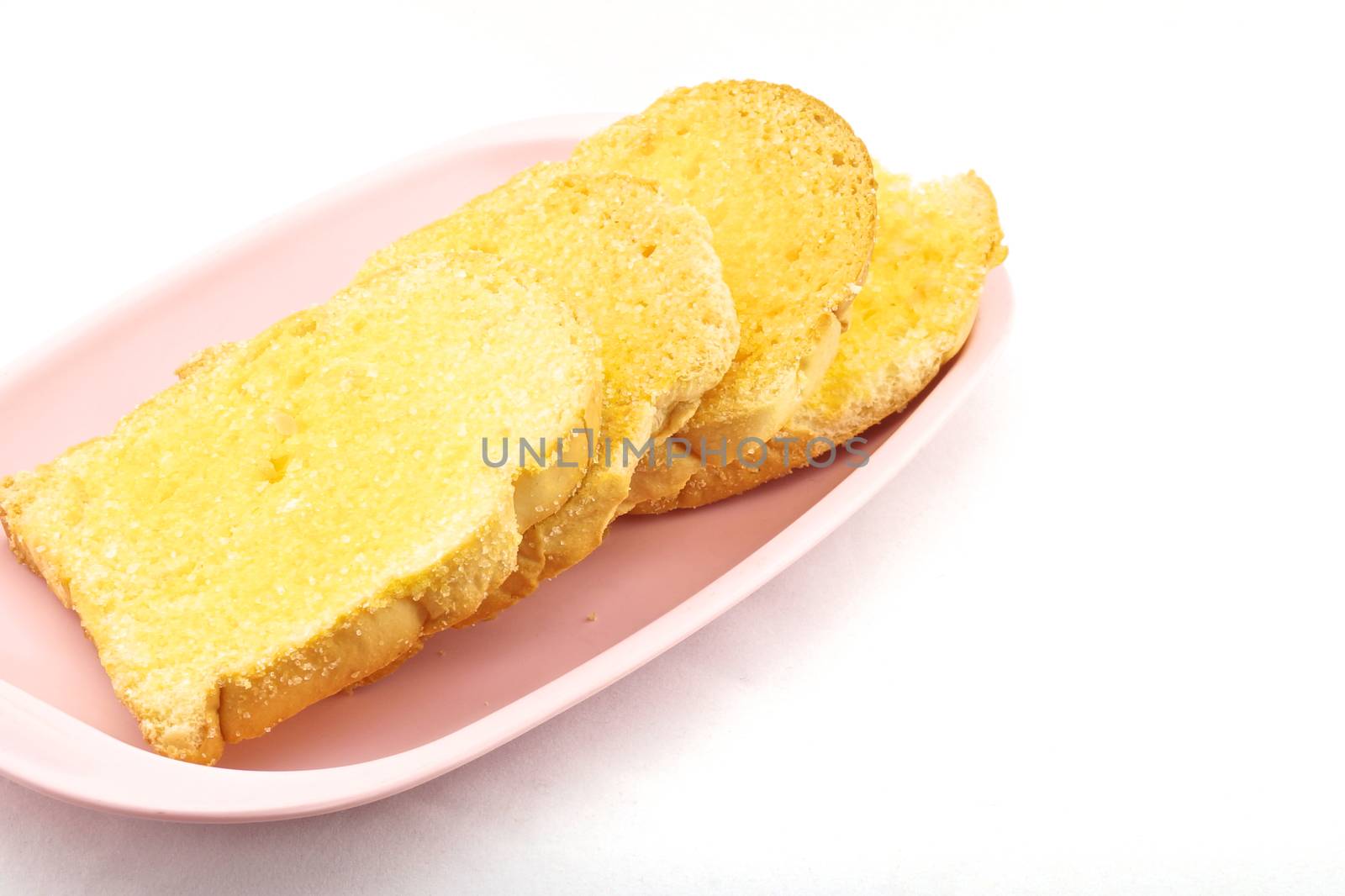 Bread baked with butter and sugar placed in a pink tray on white background.