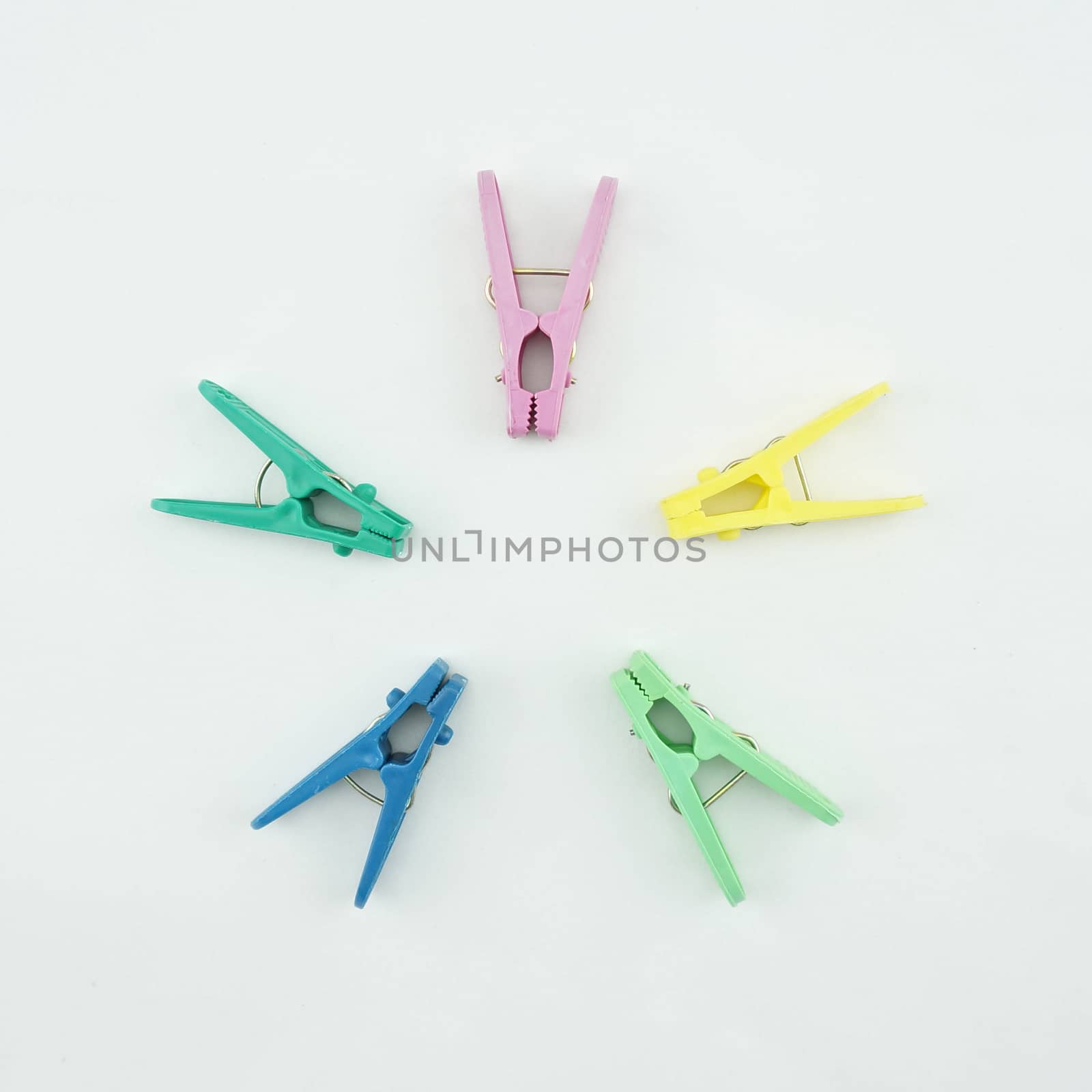 Colourful clothes Pegs put face to the center on white background.