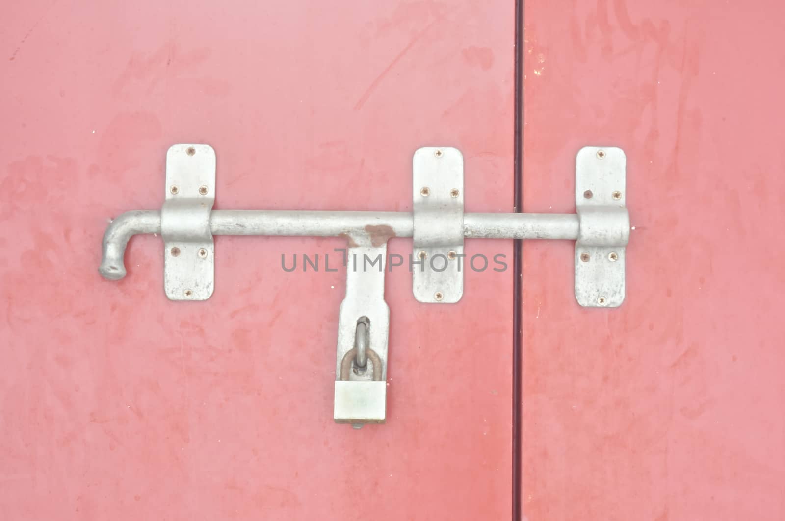 Red antique door was locked with a old silver key.