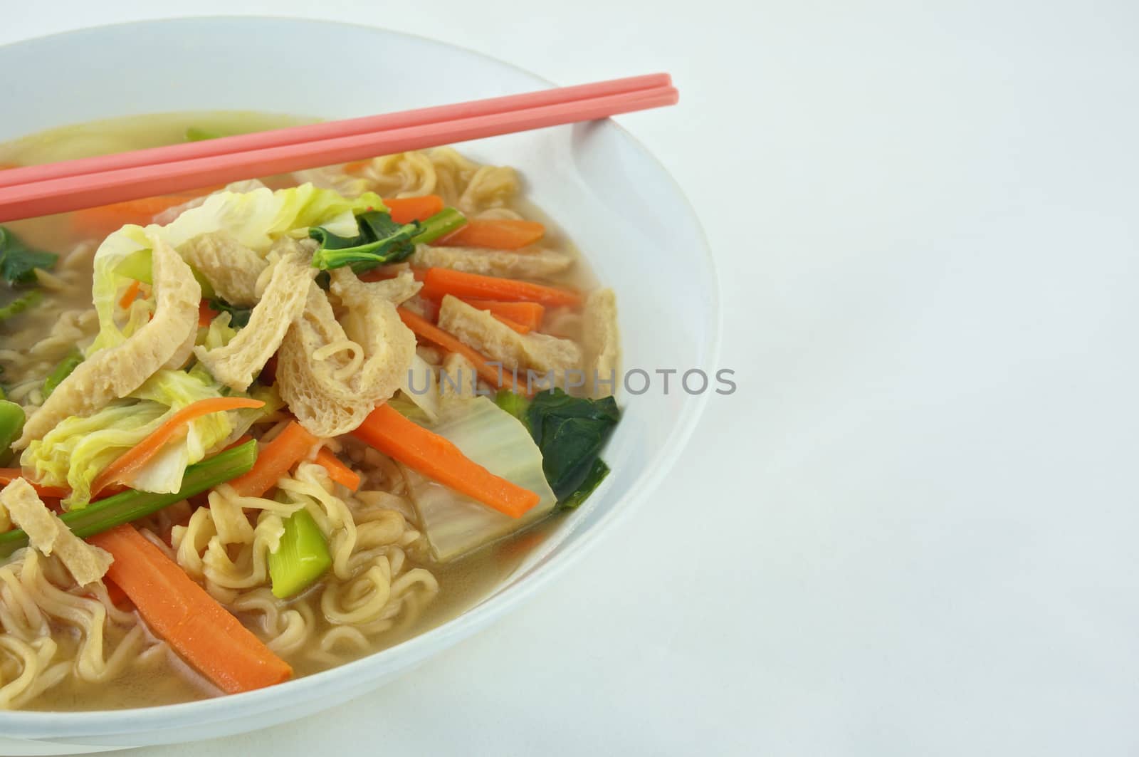 Egg noodle and clear soup vegetarian for health. It include vegan protein dry, carrot, kale and cabbage on white background.