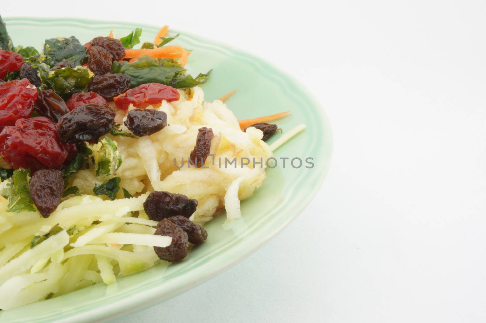 Healthy Salad consists apple carrots mango raisins and tomatoes.