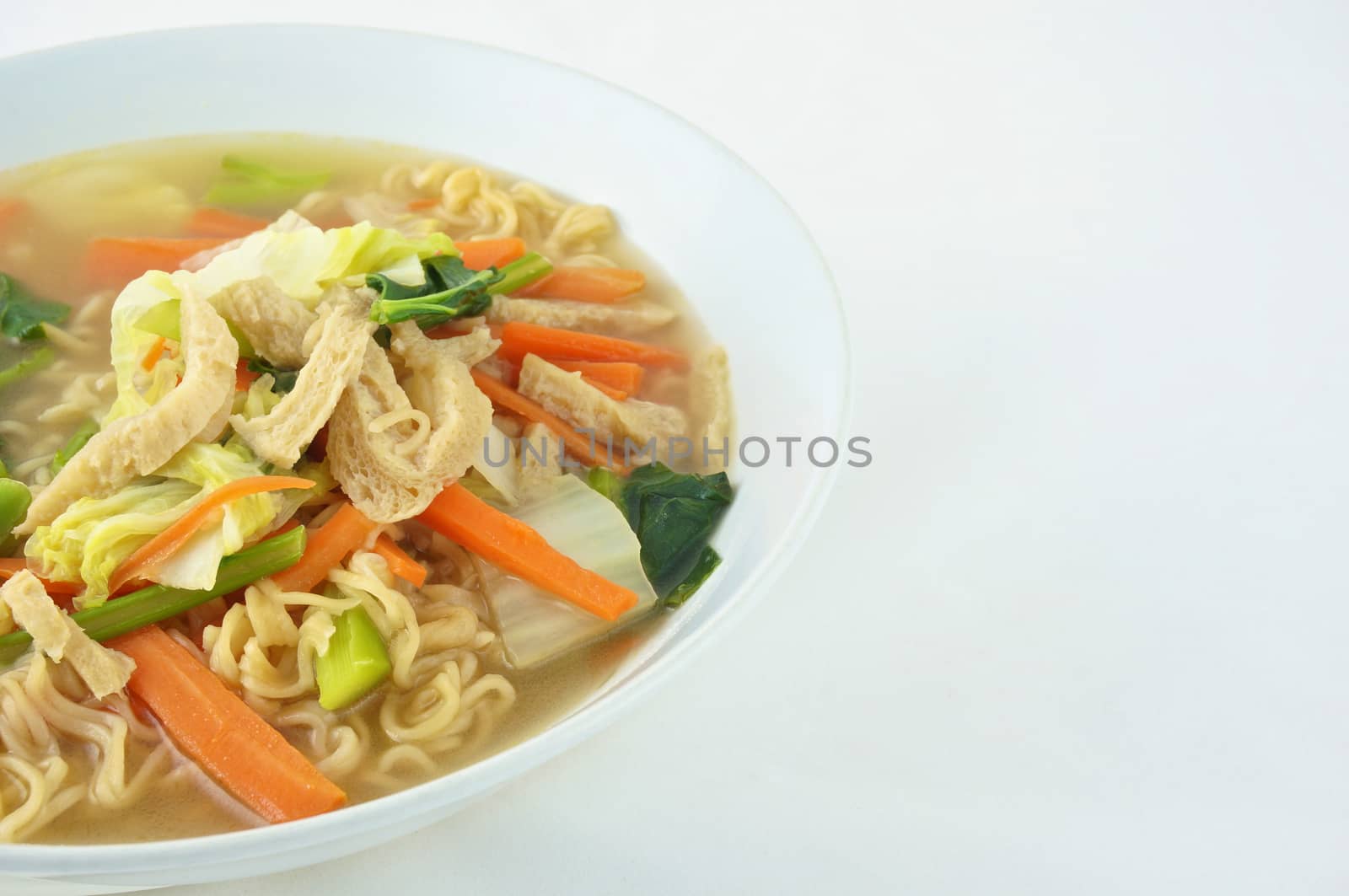 Egg noodle and clear soup vegetarian for health. It include vegan protein dry, carrot, kale and cabbage on white background.