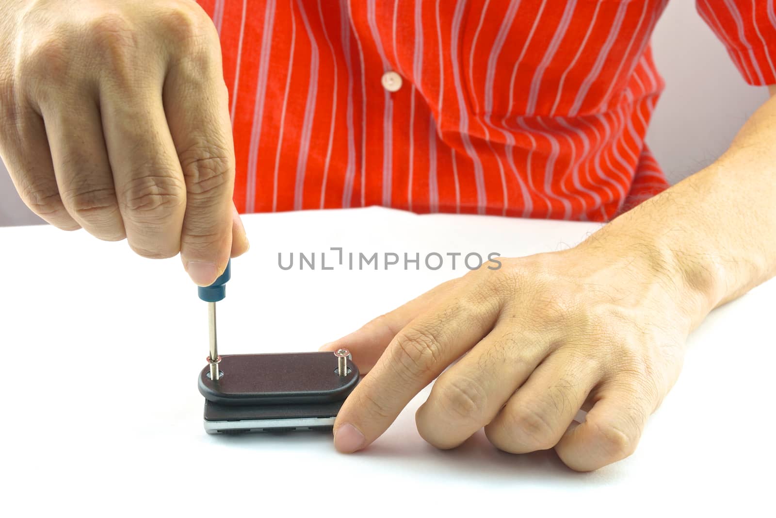 Man using screwdriver with screw for minor repair with white background.