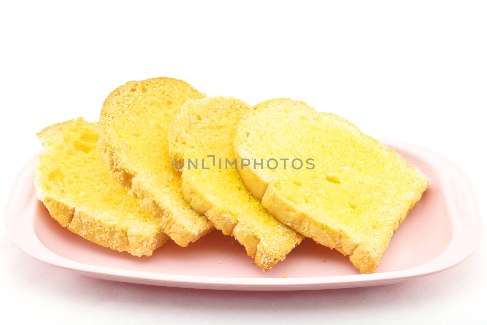 Bread baked with butter and sugar placed in a pink tray on white background.