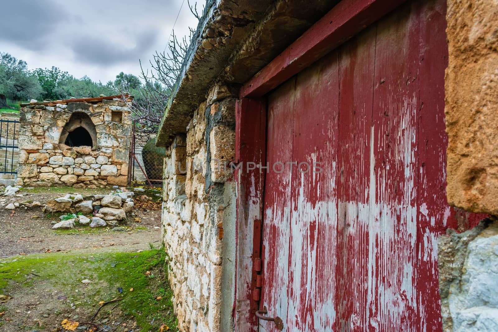 Traditional vintage house with red-brown door and an old oven