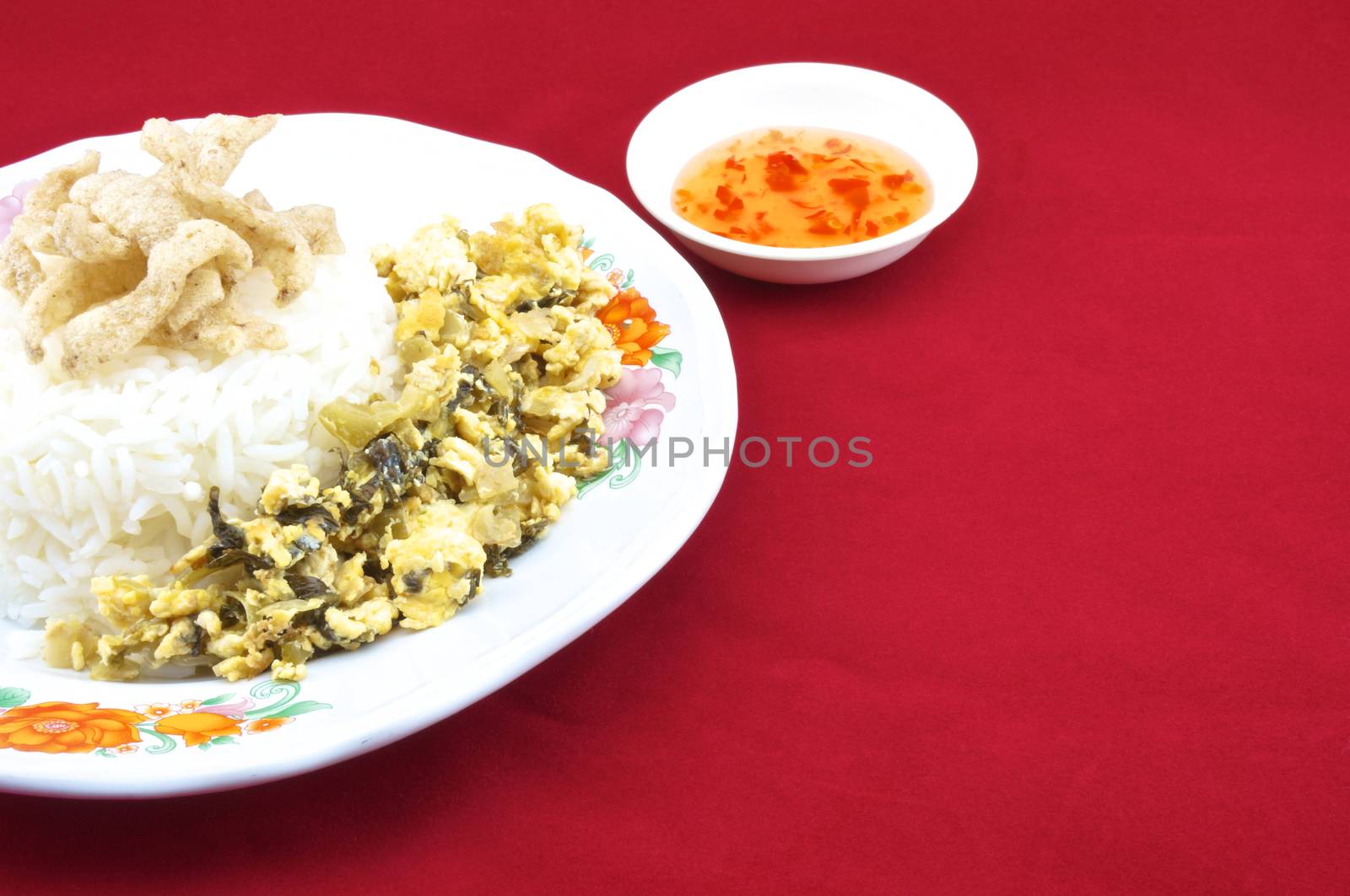 Rice , shiitake mushroom snack and egg fried pickle in plate with chilli sauce placed on a red background.