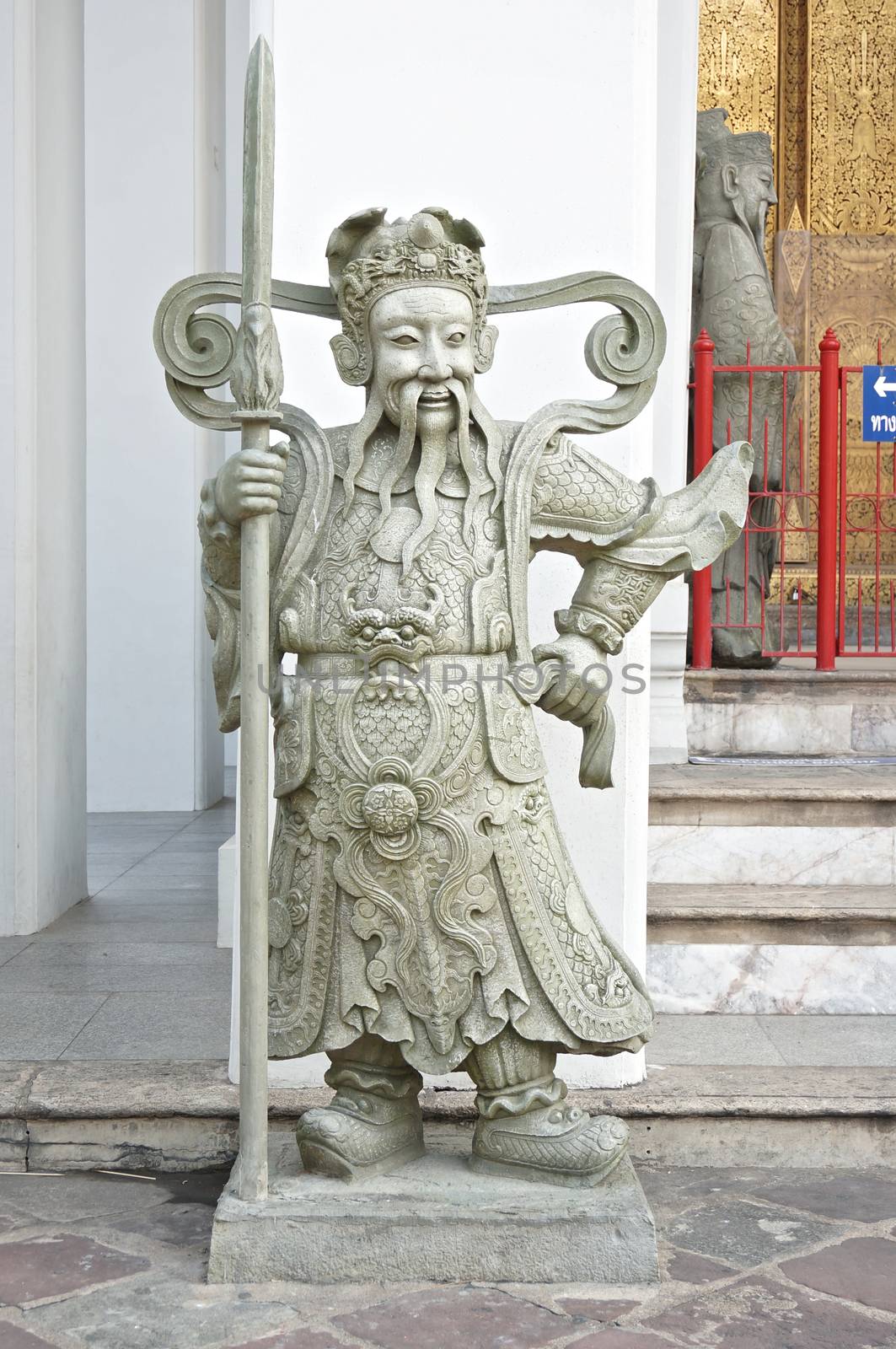 Stone statue hold lancer stand on entrance at Wat Pho