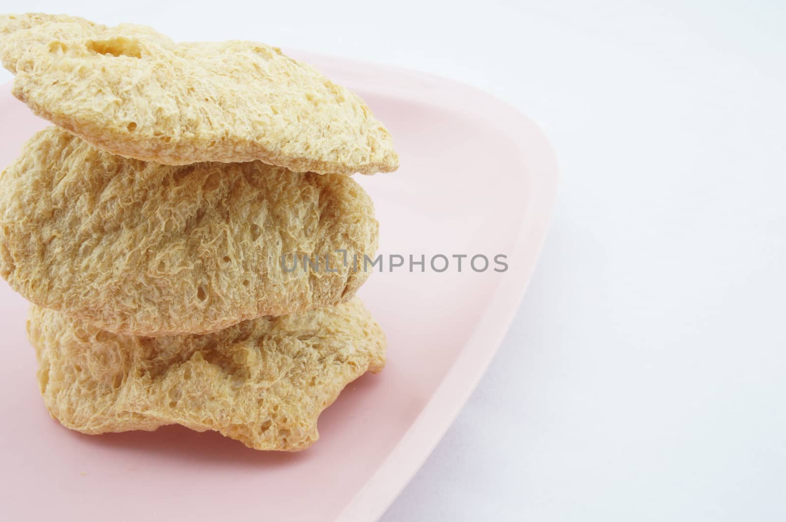 Vegan Protein Dry stacked on pink tray with white background.