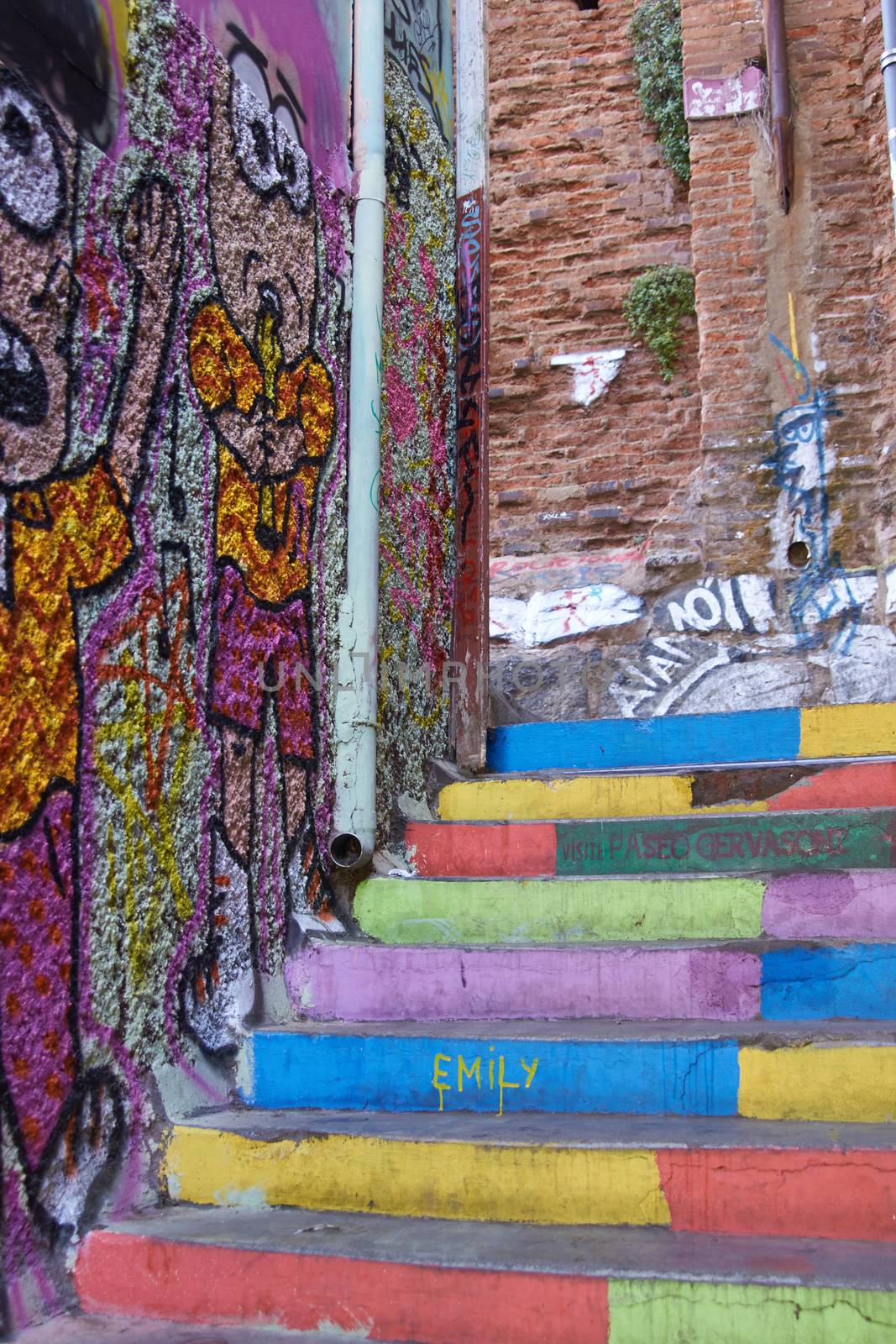 Colourful murals decorating the walls and stairs of an alleyway in the world heritage city of Valparaiso in Chile
