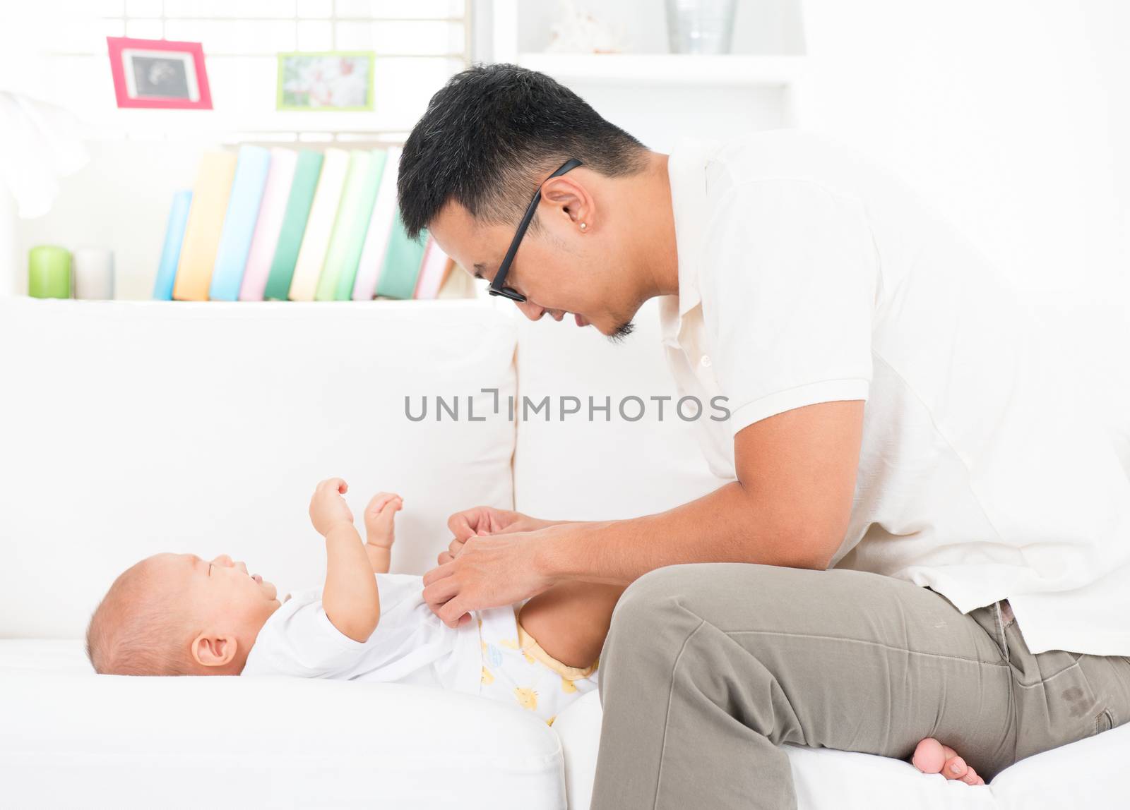 Father changing diaper and clothes for baby. by szefei