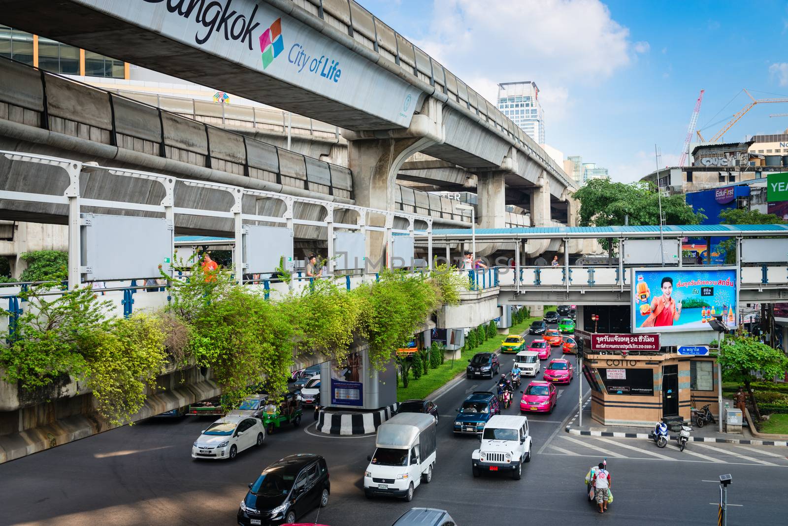 BANGKOK, THAILAND - 21 NOV 2013: Motorbikes and cars traffic move on road with pedestrian and skytrain tracks above street