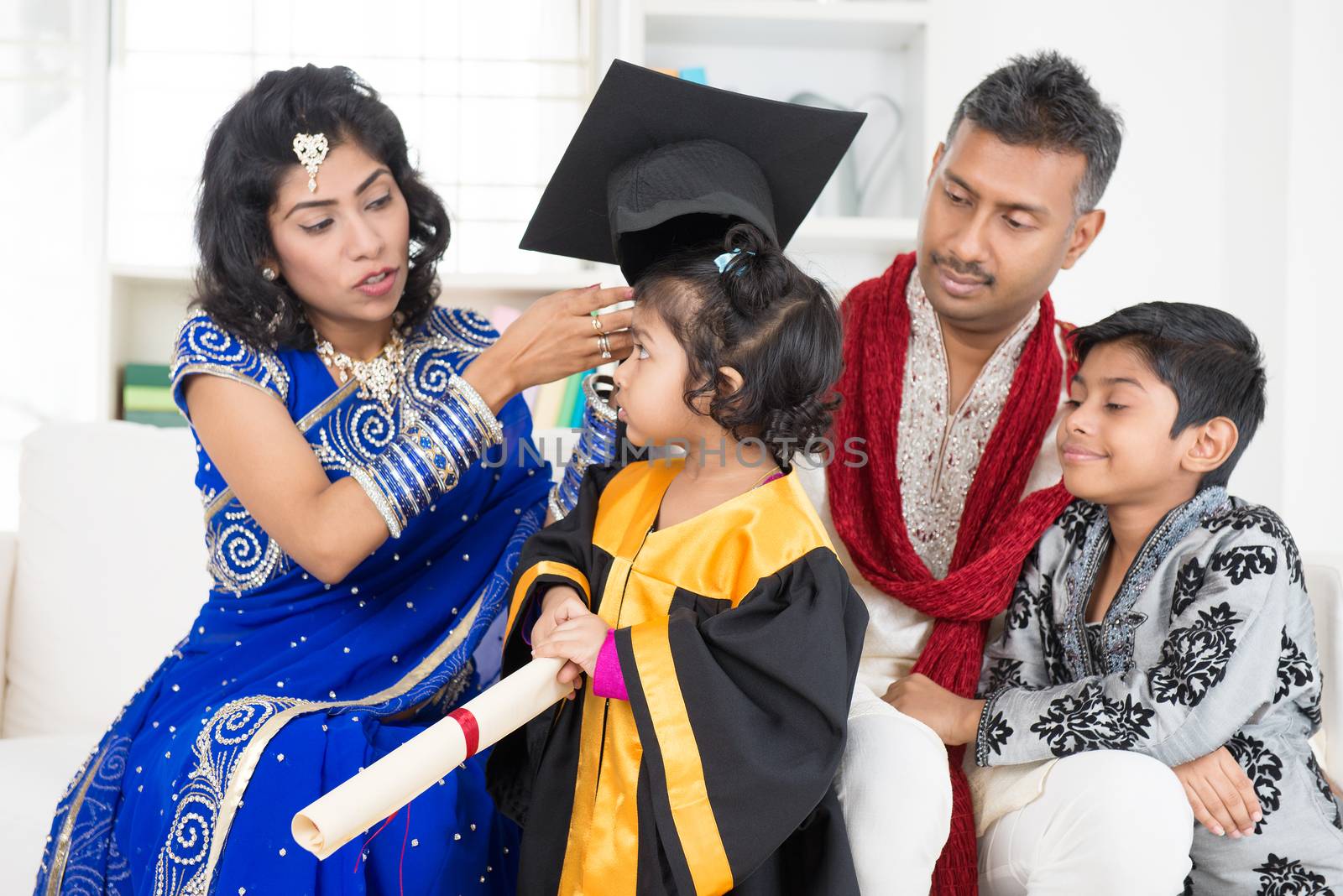 Kindergarten graduation. Asian Indian family, parents and children on kinder graduate day.