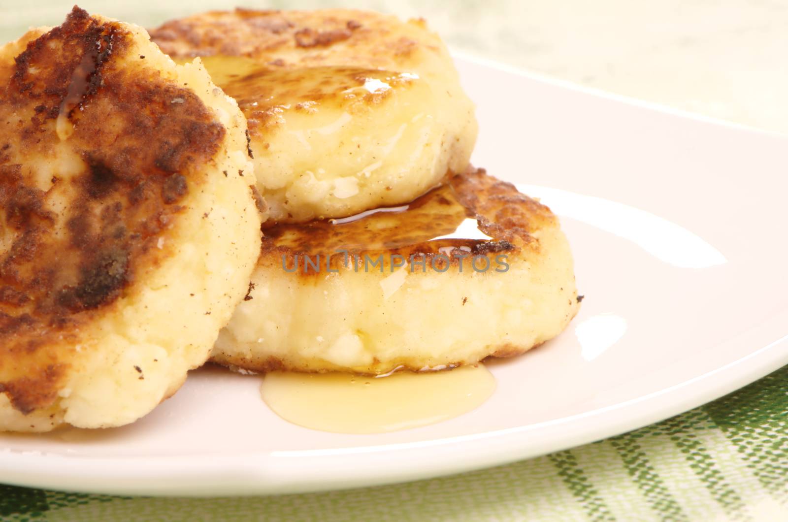 Delicious homemade cheese pancakes with honey closeup