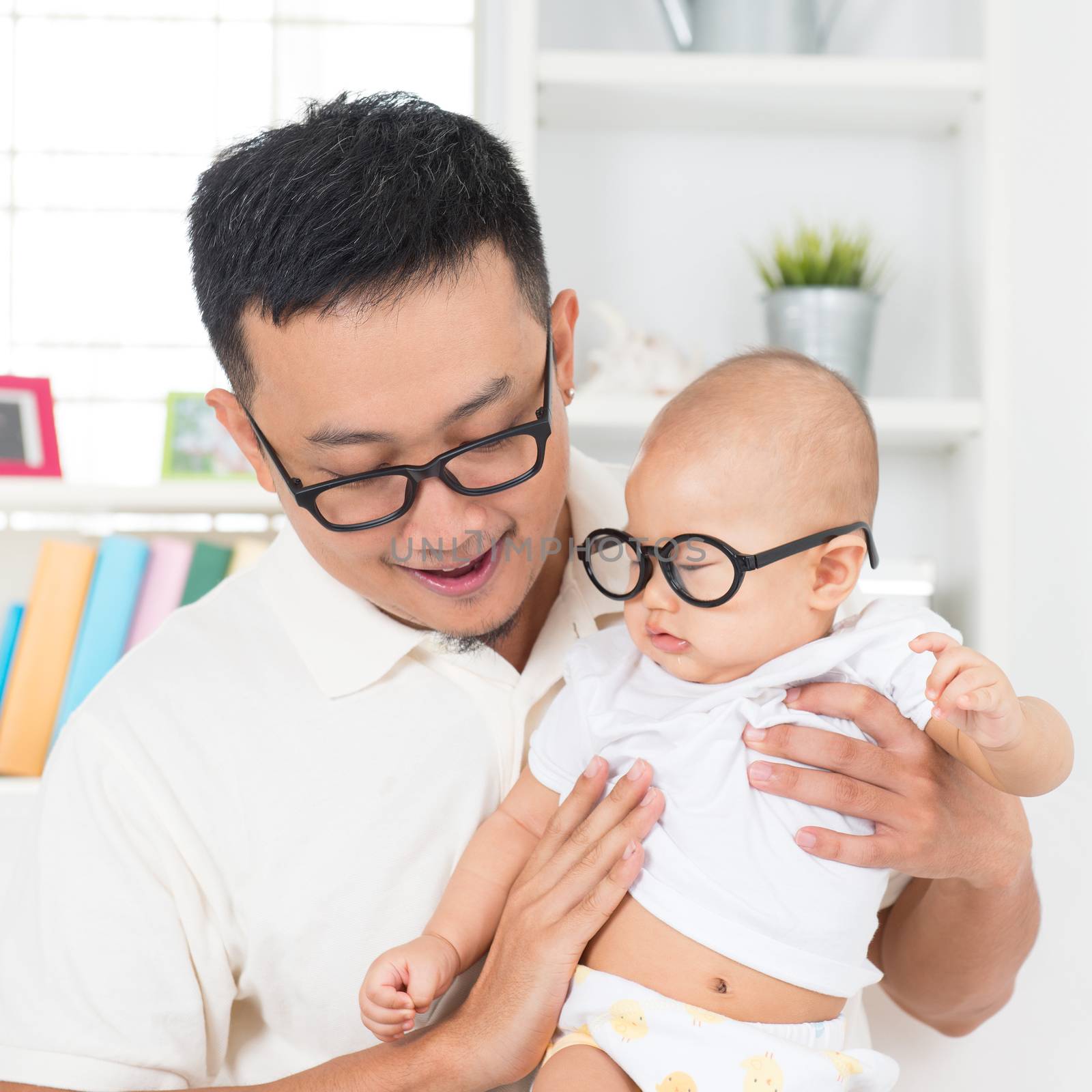 Young father and child with nerd glasses. Asian family at home.
