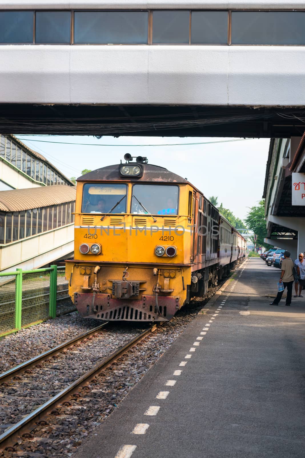 Locomotive with train arrives at railway station in Thailand by iryna_rasko