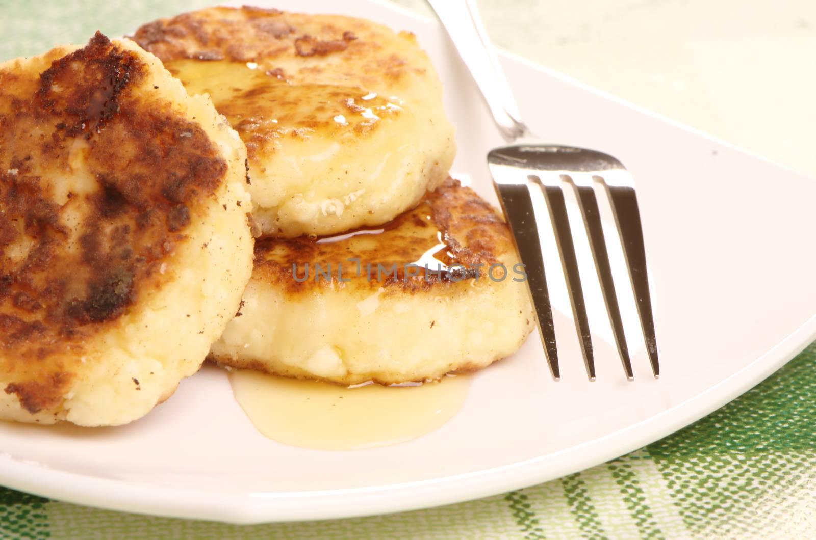 Delicious homemade cheese pancakes with honey closeup