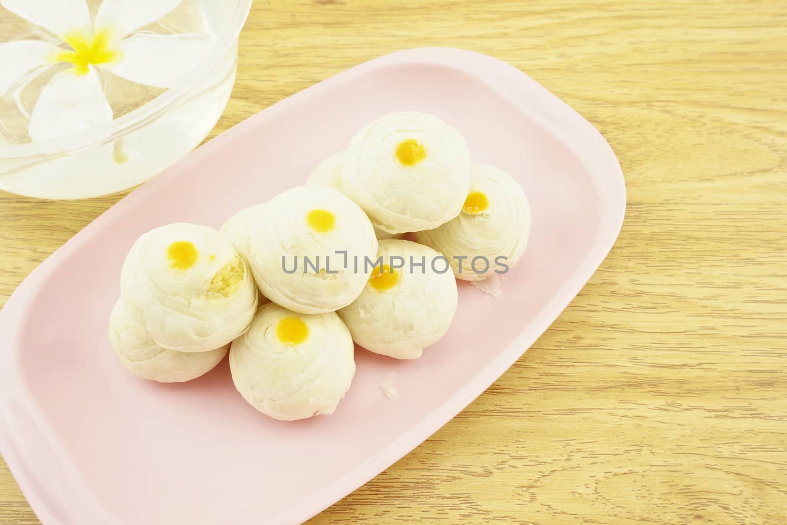 Chinese pastry place on a pink tray with wood background.