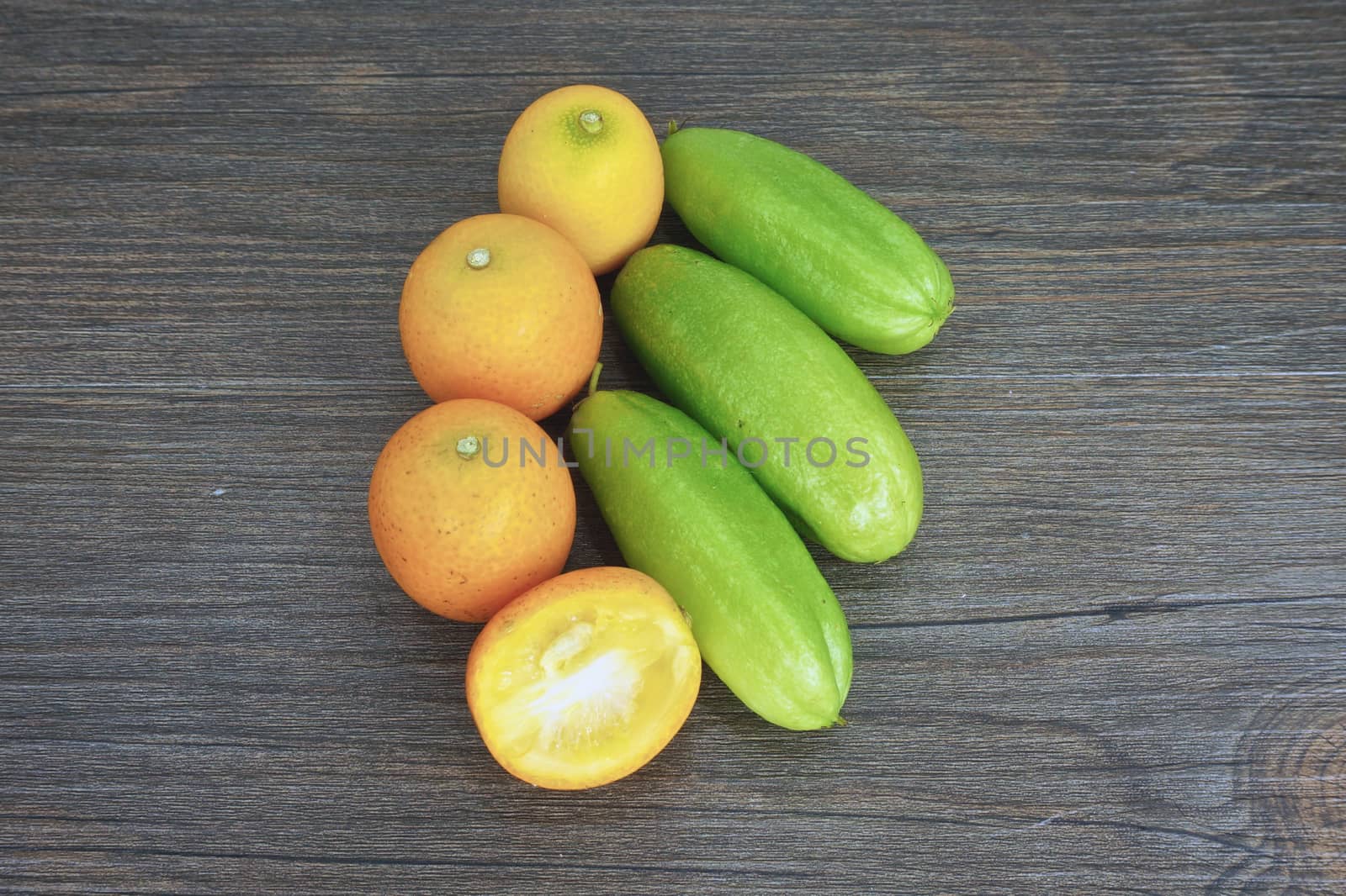 Averrhoa bilimbi or cucumber and orange place on wood background