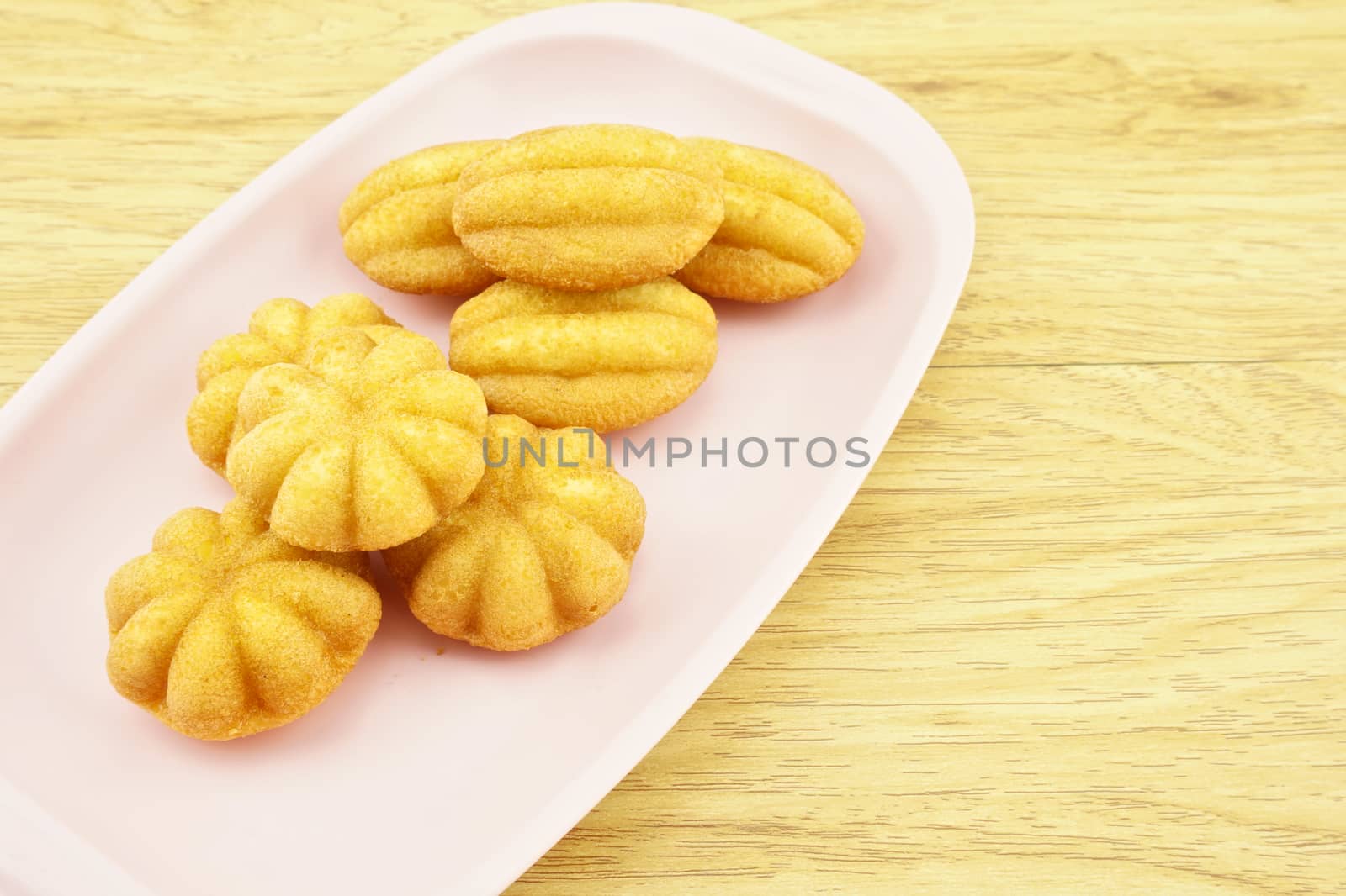 Egg cake is thai bakery put on pink tray with wood background.