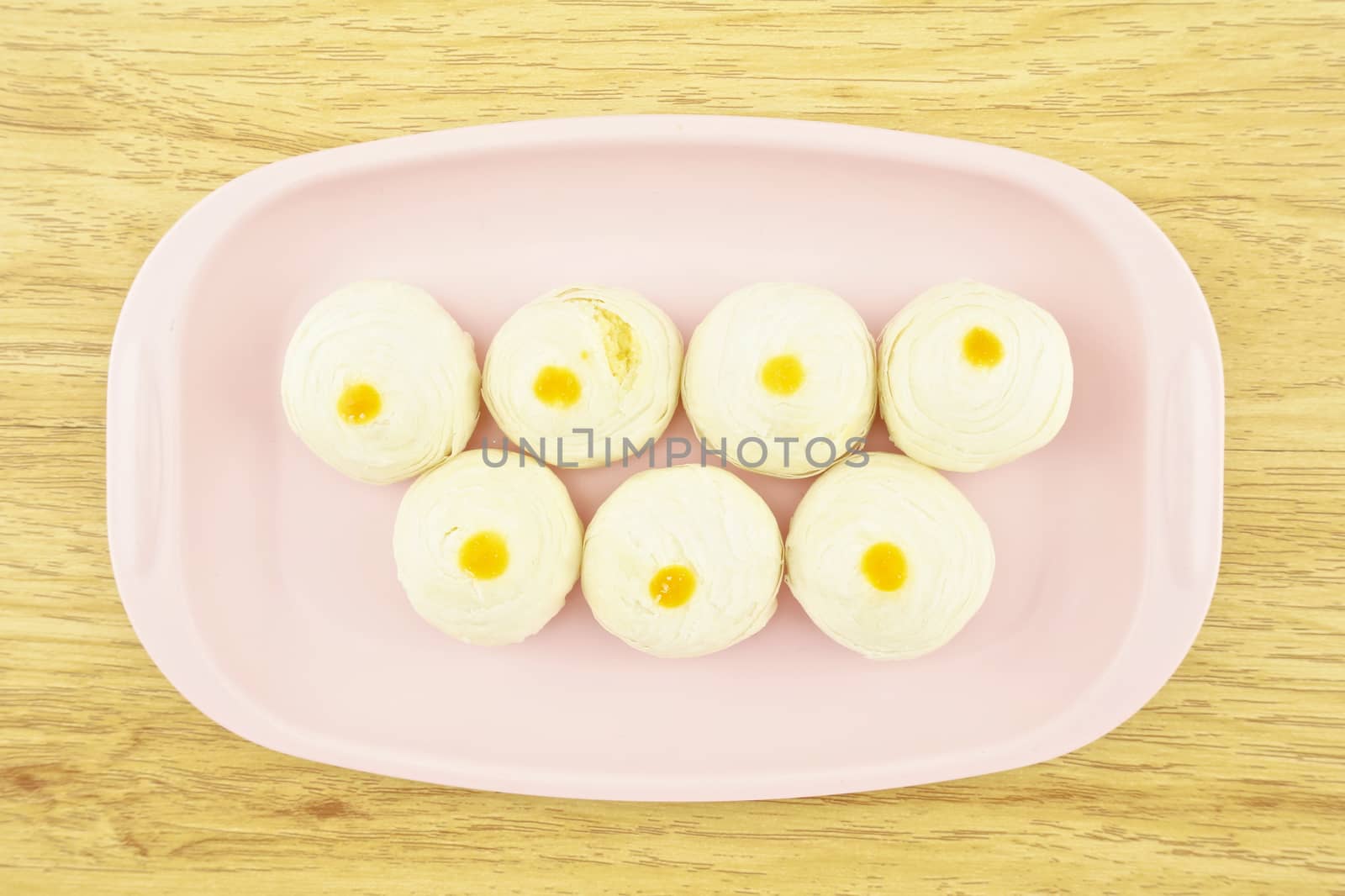 Chinese pastry place on a pink tray with wood background.