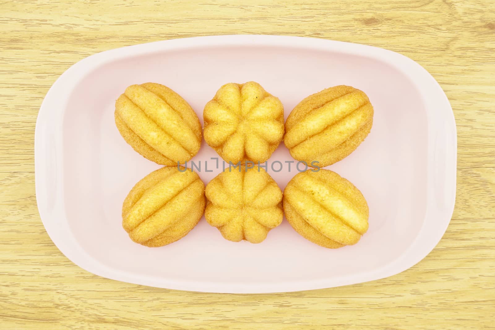 Egg cake is thai bakery put on pink tray with wood background.