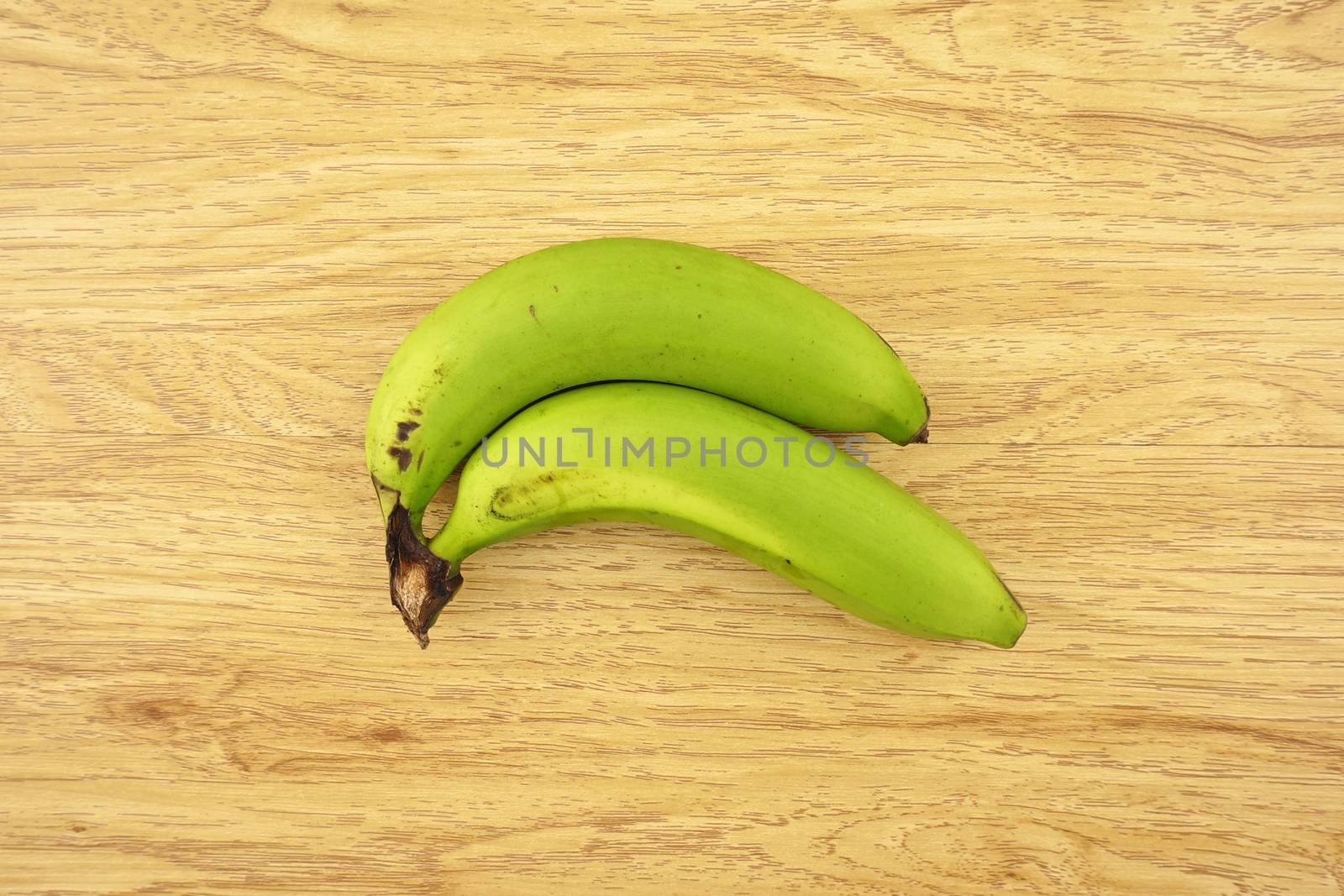 Green cavendish banana put on wood background.