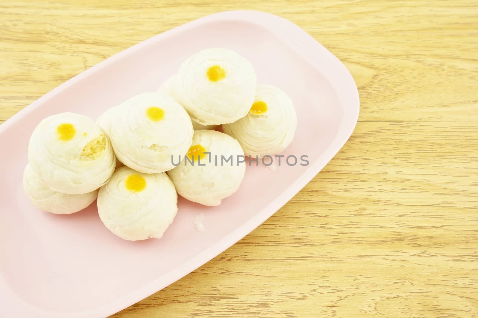 Chinese pastry place on a pink tray with wood background.