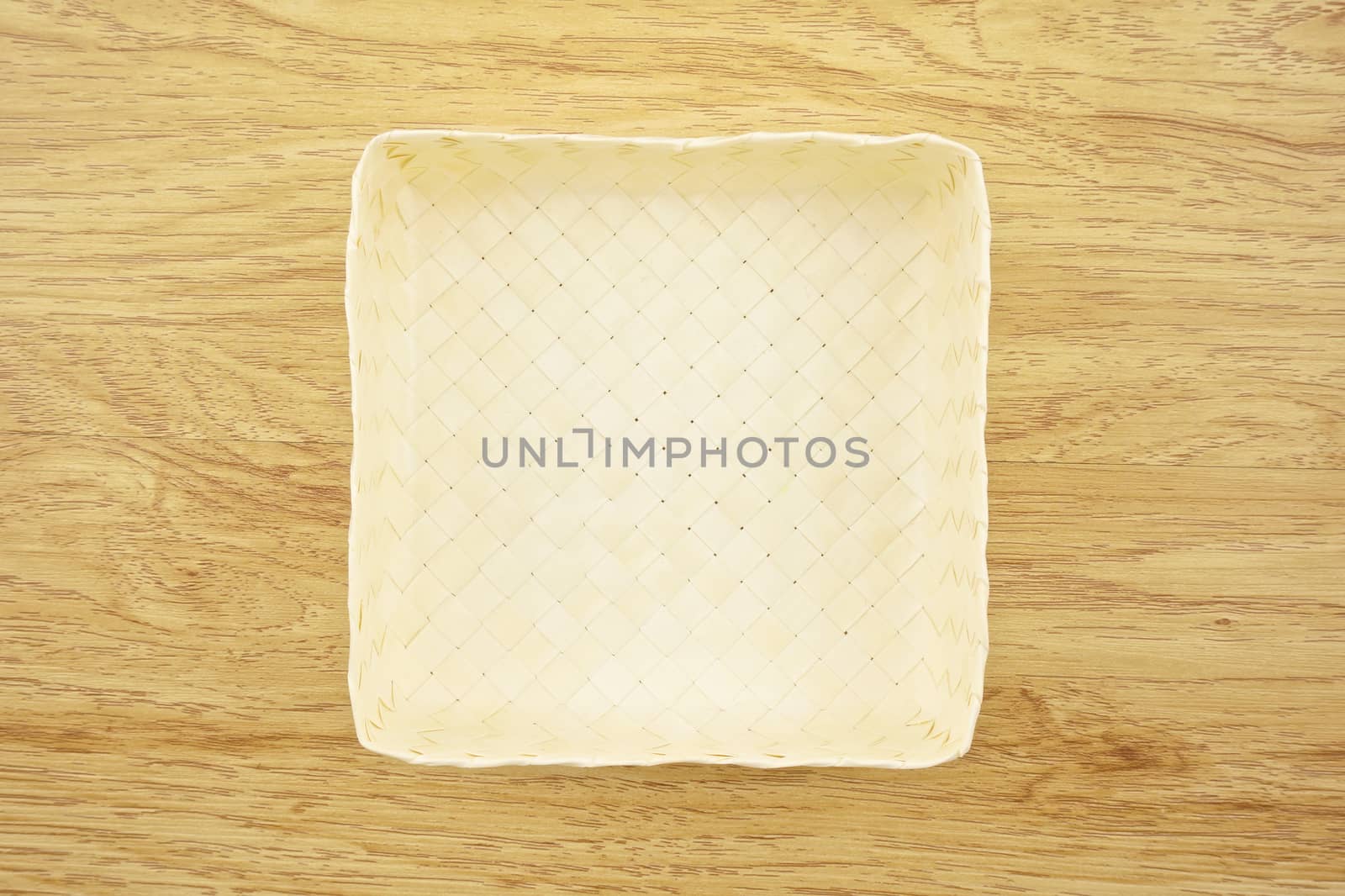 Cream basket wicker from palm leaves place on wood background.