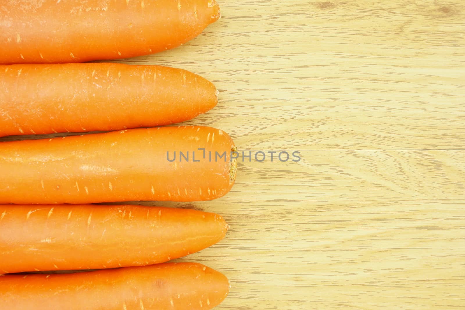 Orange carrot side of wood background by eaglesky