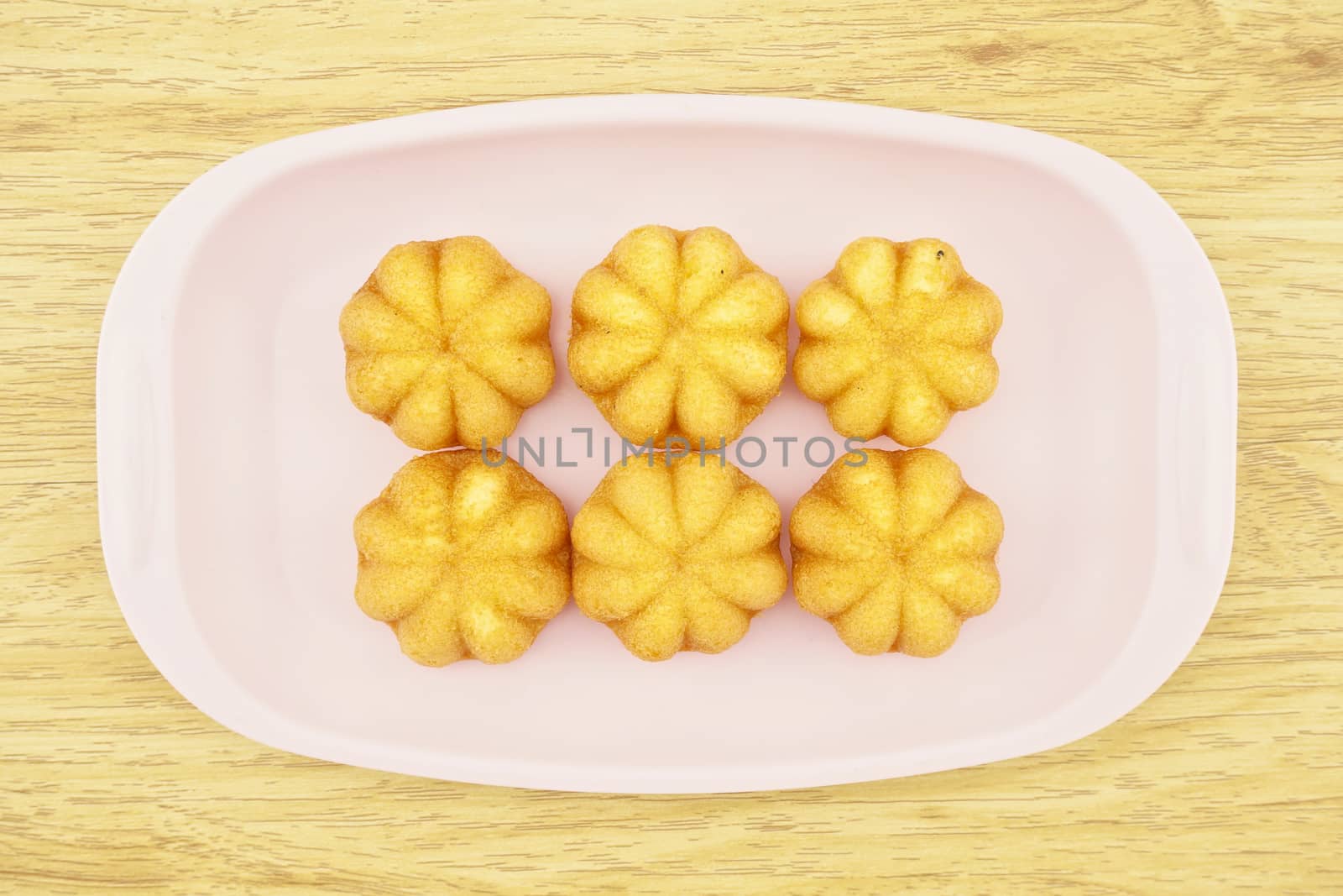 Egg cake is thai bakery put on pink tray with wood background.