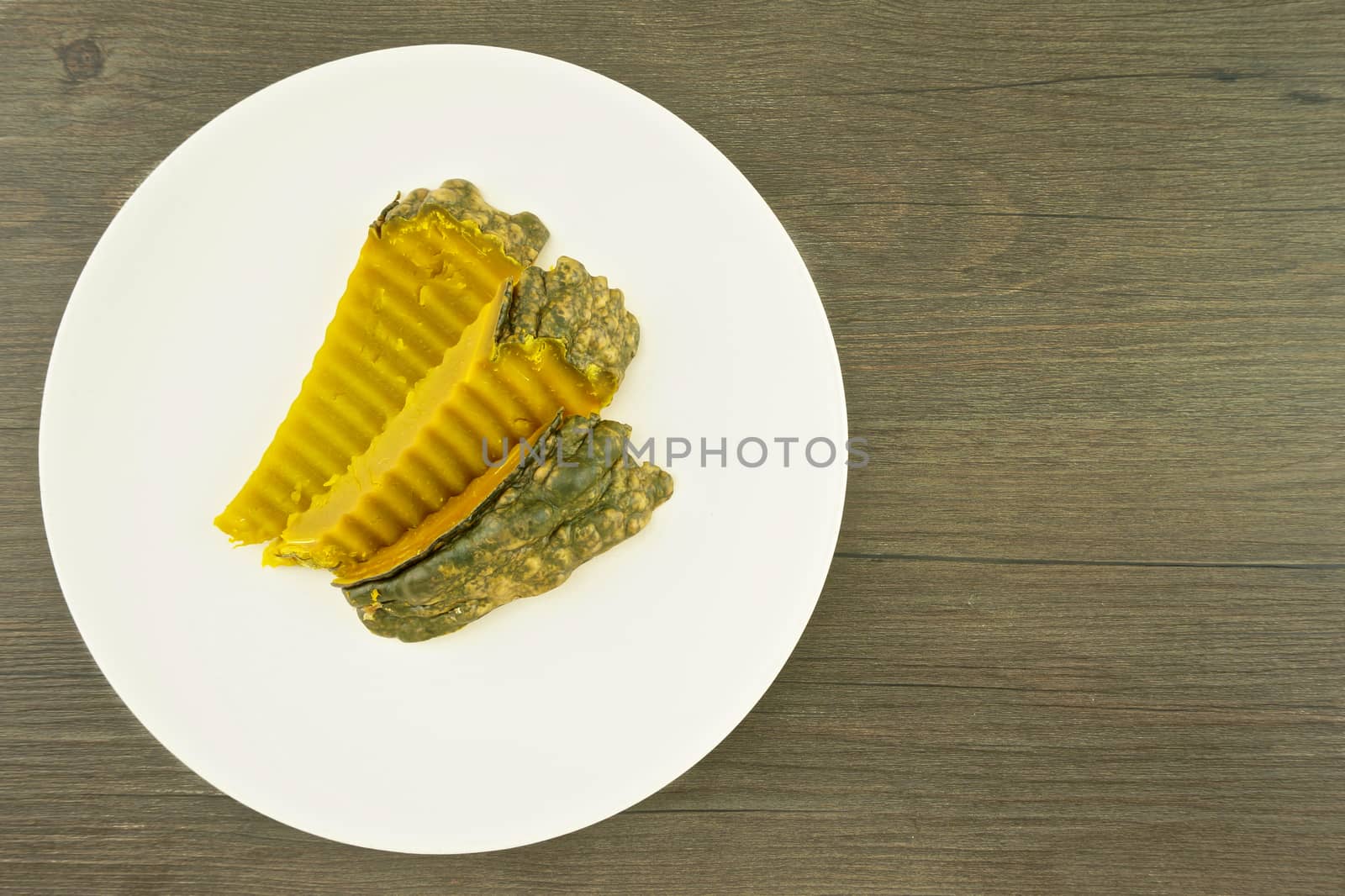 Steam pumpkin Thai dessert place on dish with wood background.