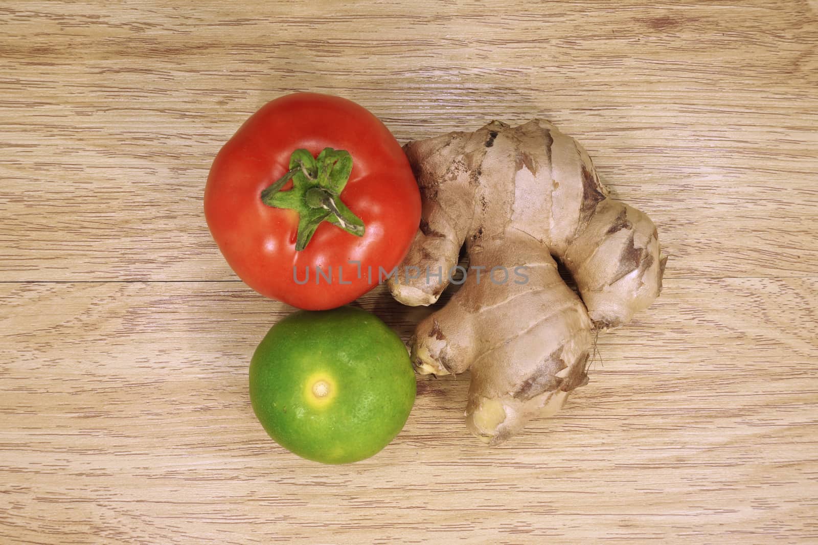 Tomato, lemon, ginger is colorful vegetable put on wood background.