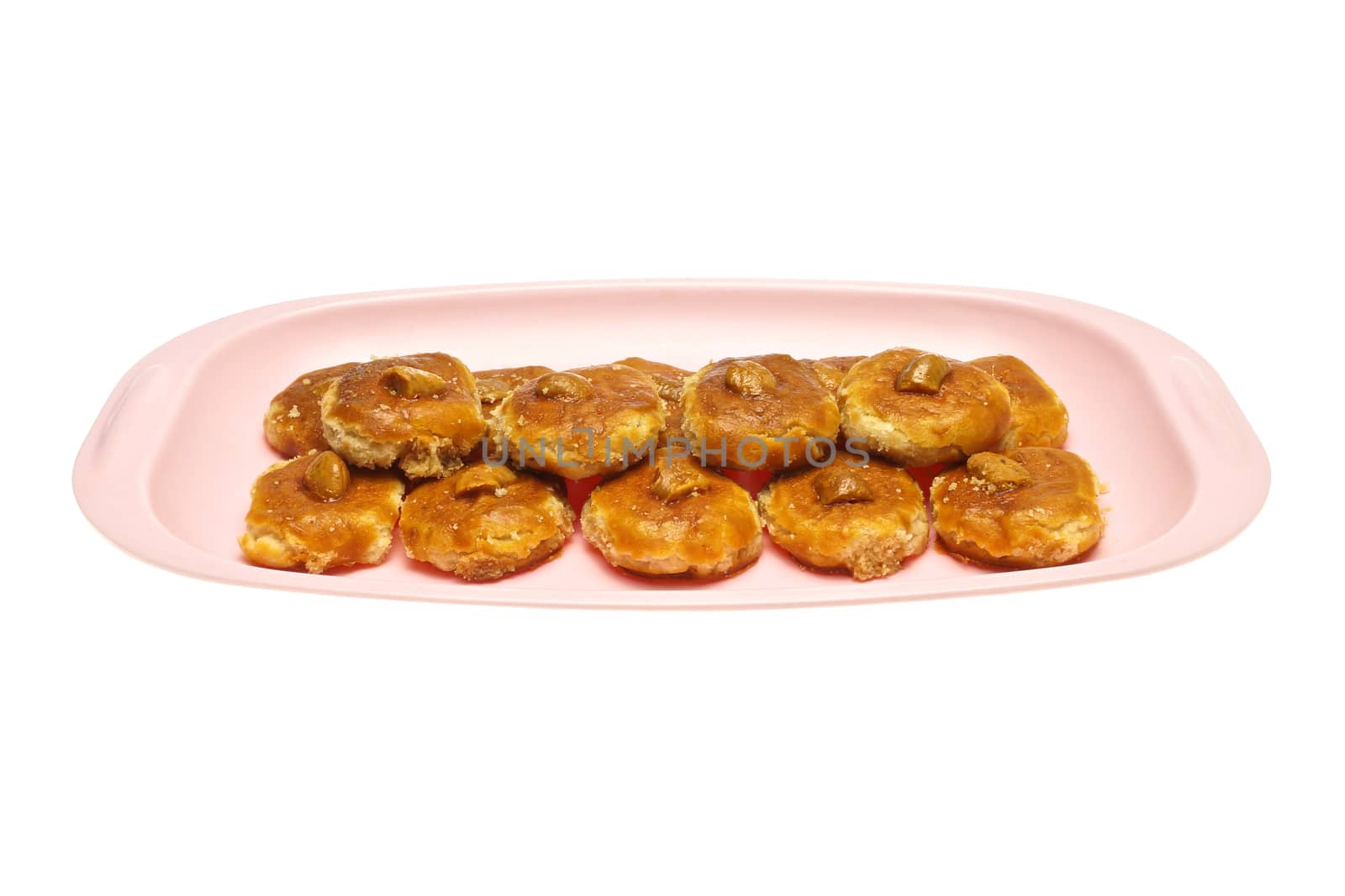 Cookie and cashew nut put on pink tray isolated with white background.