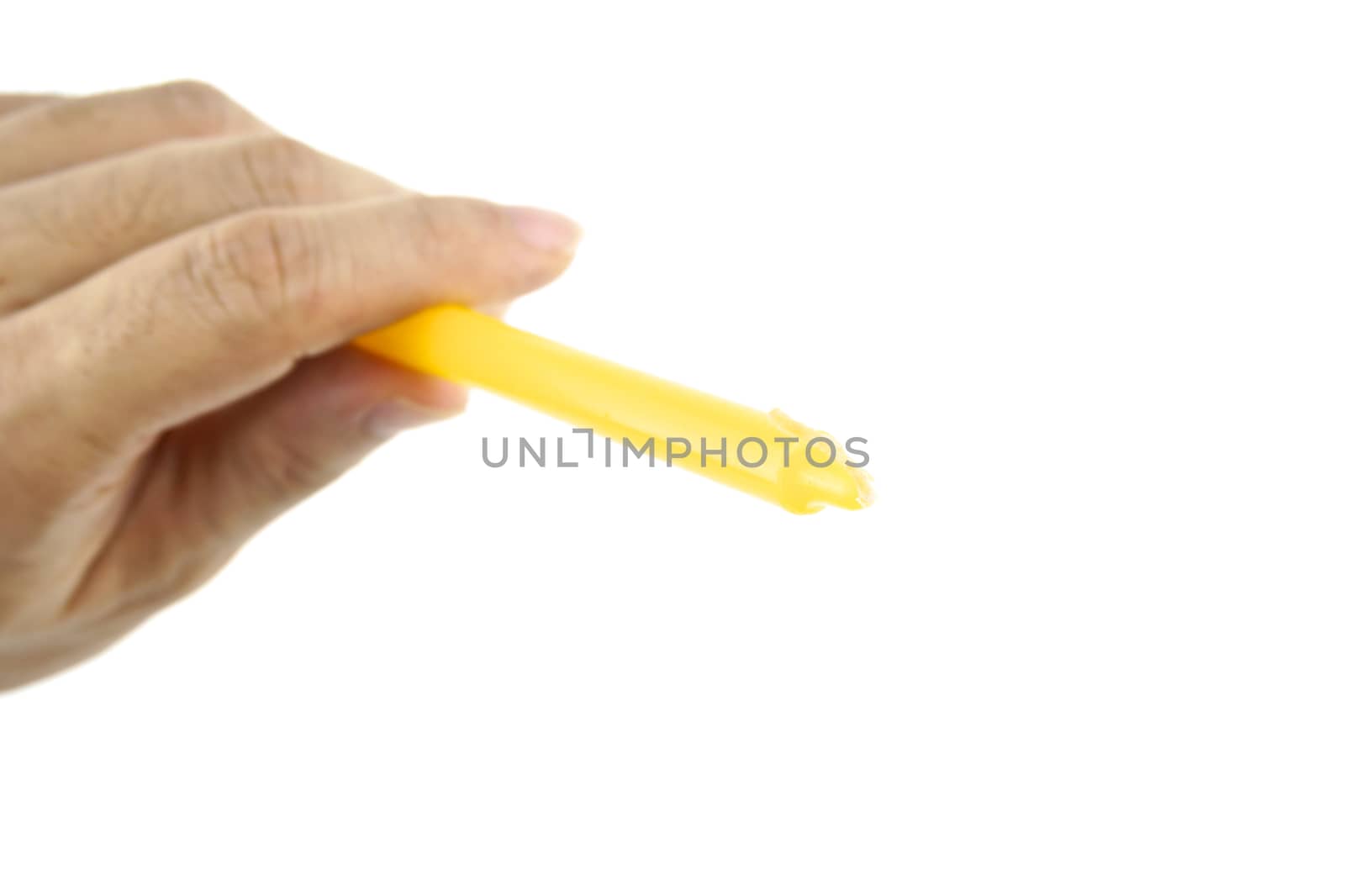 Hand hold yellow candle for lit from top left isolated with white background.